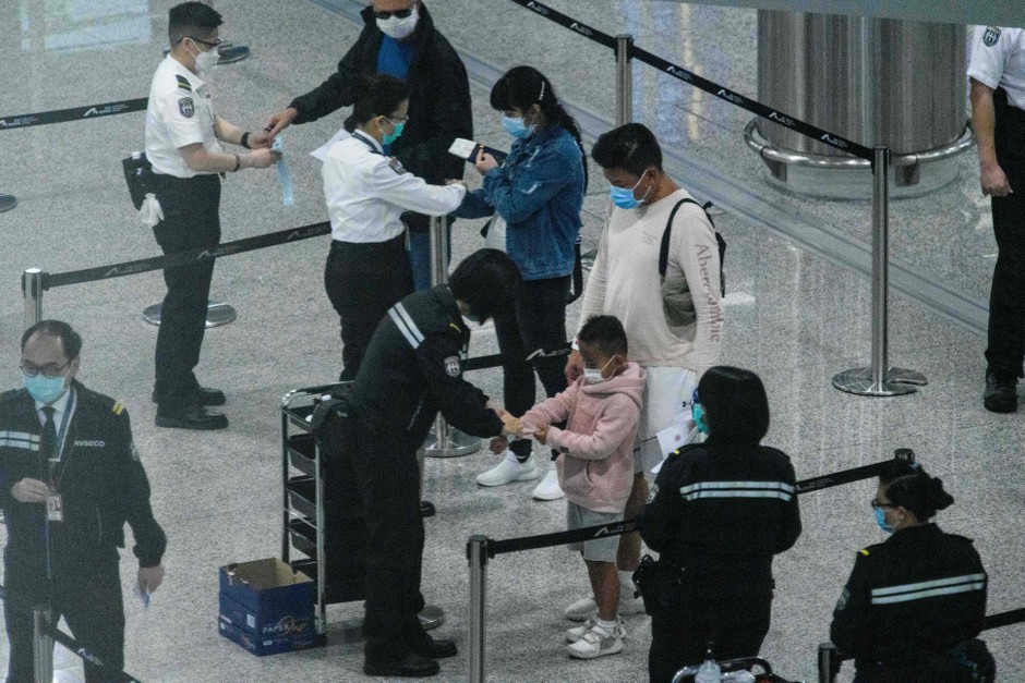 Arrivals to Hong Kong's airport receive tracking bracelets for two weeks of self-quarantine.