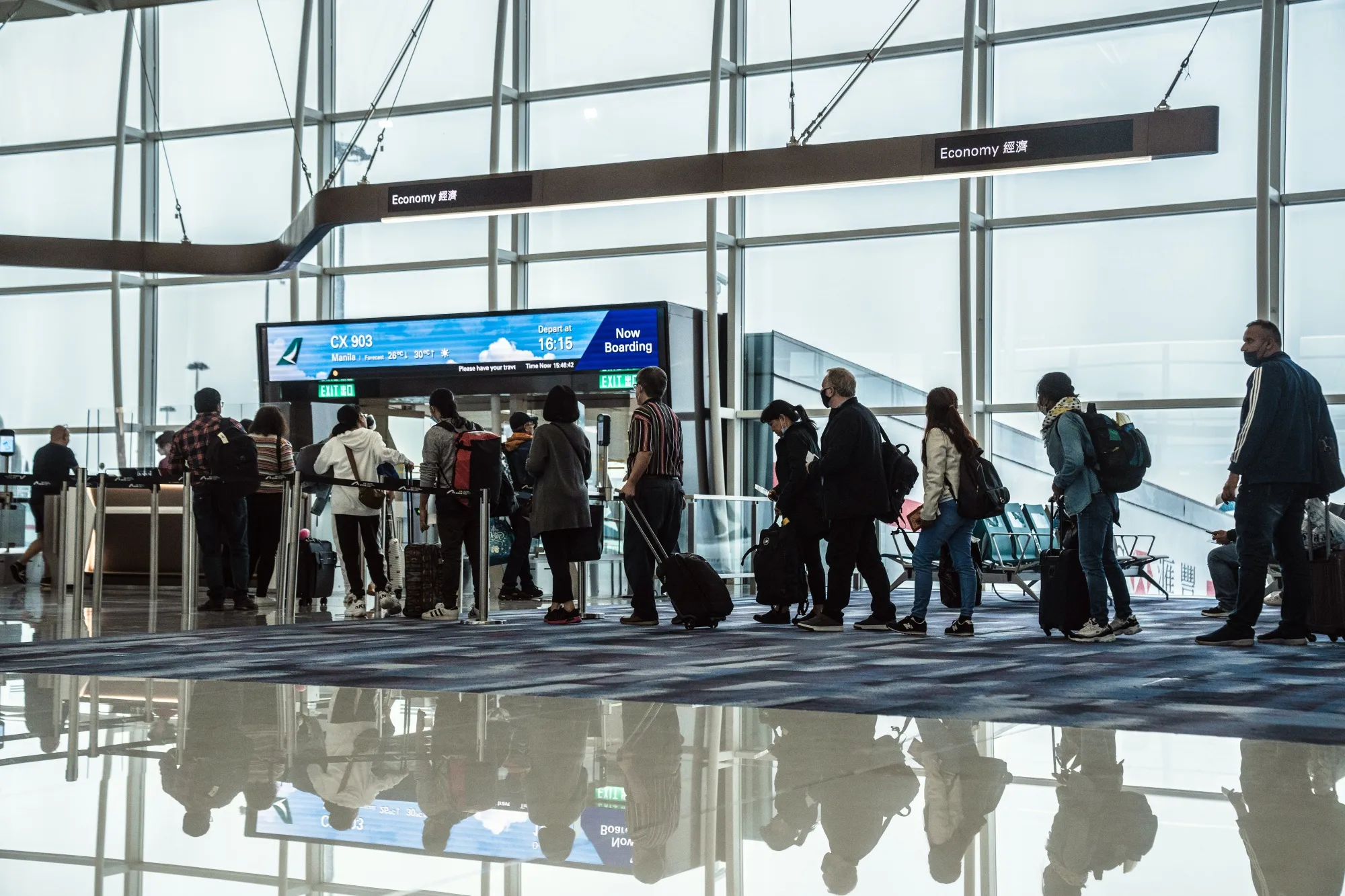 Passengers line up to board a Cathay Pacific flight at Hong Kong International Airport.
