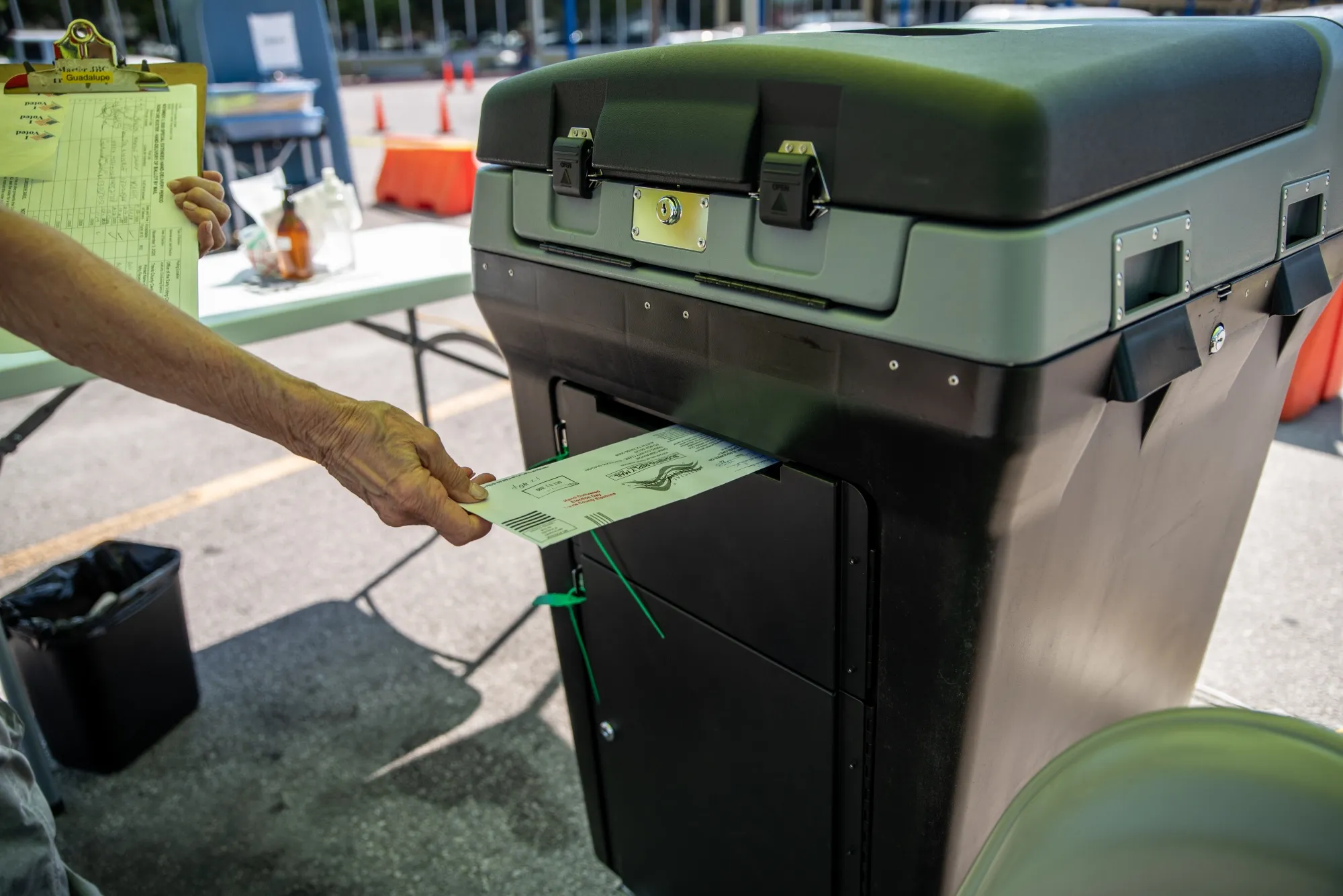 A worker puts a ballot into a lock box at a drive-thru mail ballot hand delivery center in Austin, Texas, U.S., on&nbsp;Oct. 2.