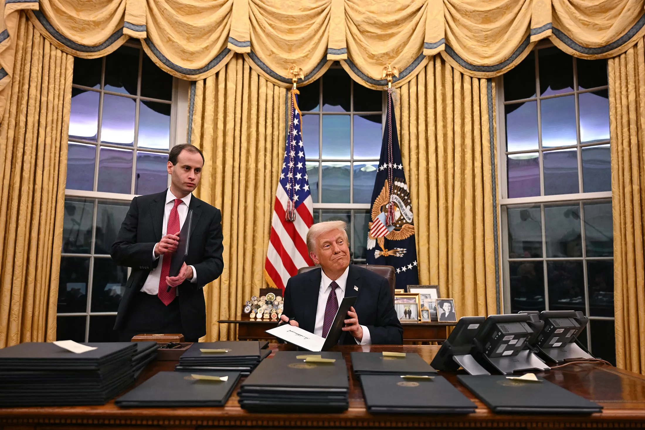 President Donald Trump signs executive orders in the Oval Office of the White House in Washington, DC, on Jan. 20.