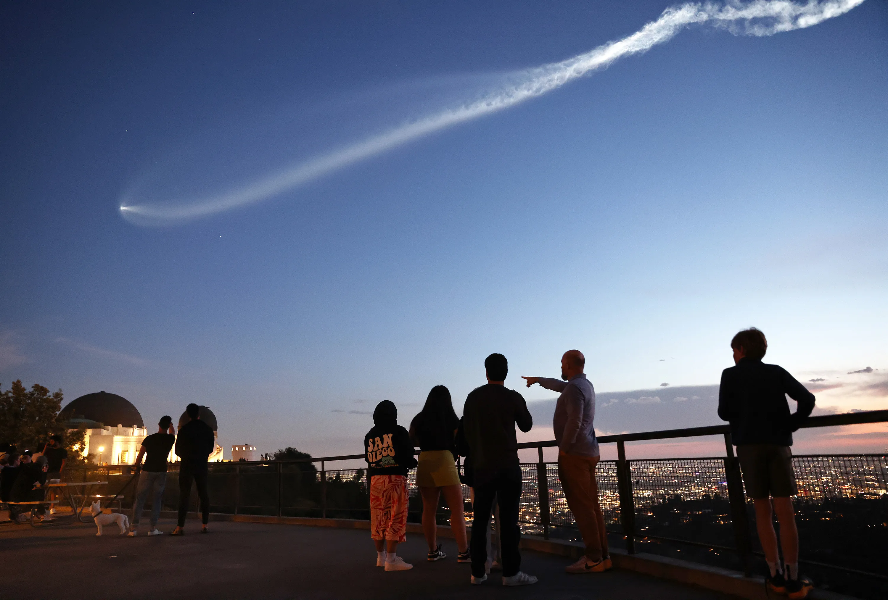 People watch a SpaceX Falcon 9 rocket carrying a payload of 22 Starlink internet satellites into space, after launching from Vandenberg Space Force Base, on March 18, 2024.