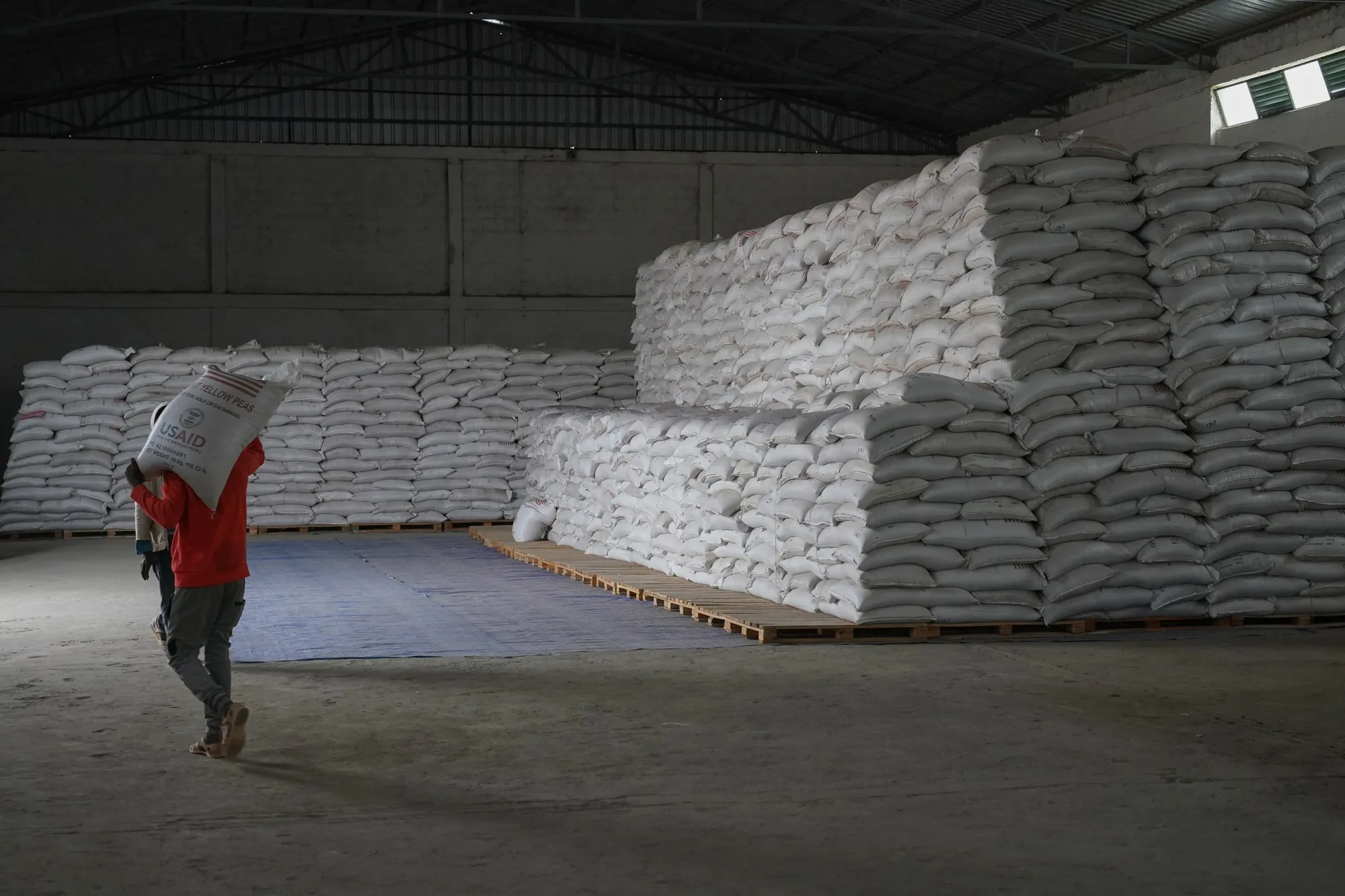 Aid workers move bags of yellow lentils at an aid operation in Mekele, Ethiopia.