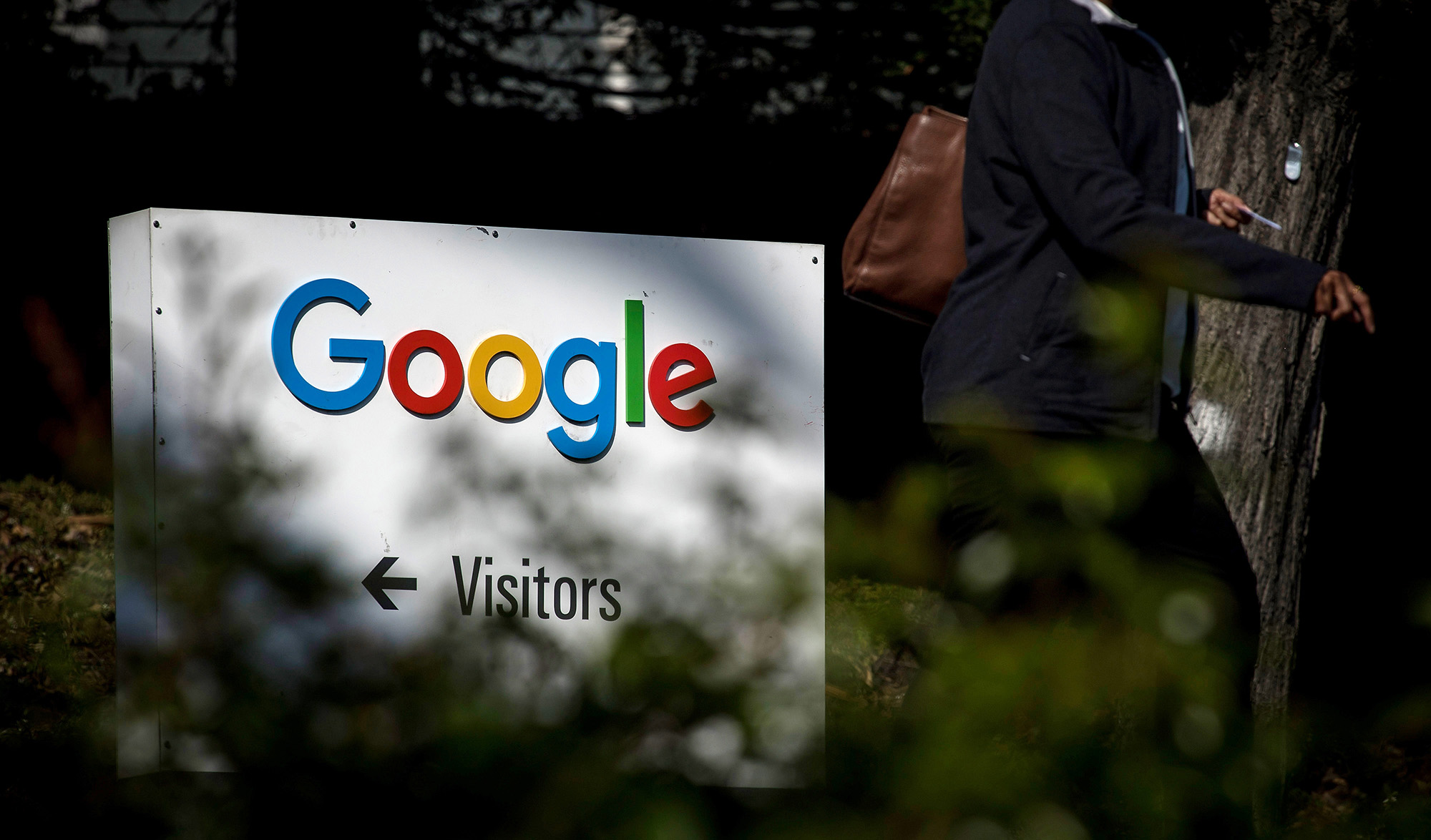 A pedestrian walks past signage at Google Inc. headquarters in Mountain View, California.