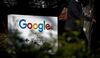A pedestrian walks past signage at Google Inc. headquarters in Mountain View, California.