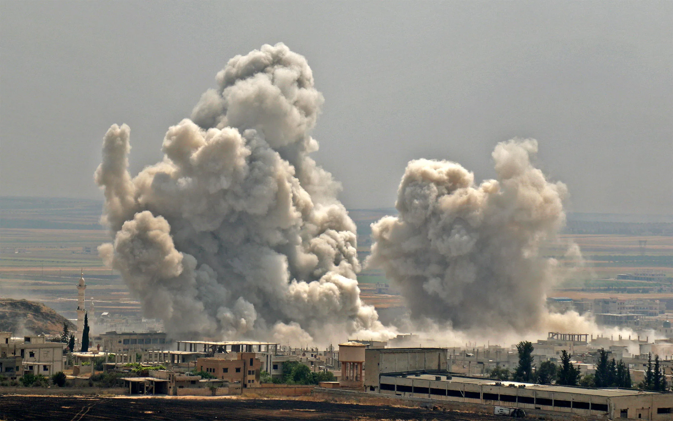 Plumes of smoke rise following reported Syrian government forces' bombardment on the town of Khan Sheikhun in the southern countryside of the jihadist-held Idlib province, on June 7, 2019.&nbsp;