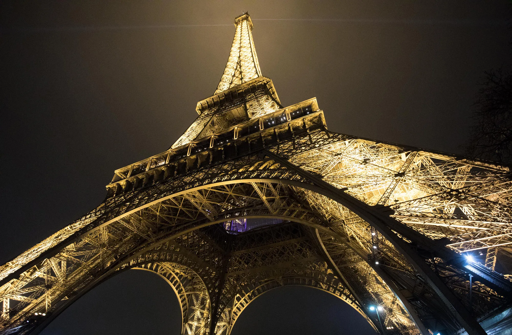 The Eiffel Tower stands illuminated at night in Paris.
