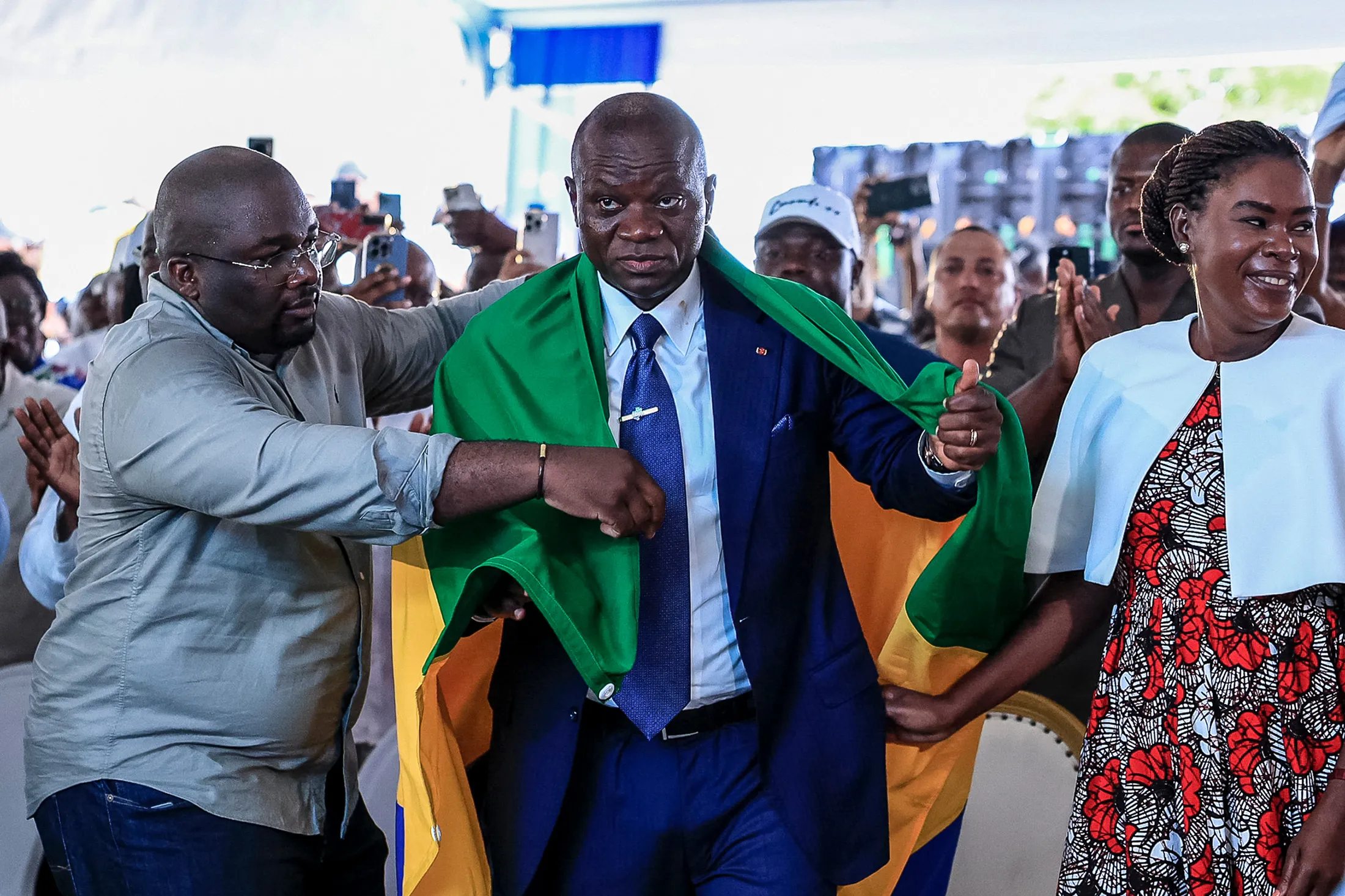 Brice Oligui Nguema is draped with a Gabon flag while celebrating his presidential election at his campaign headquarters in Libreville on April 13.