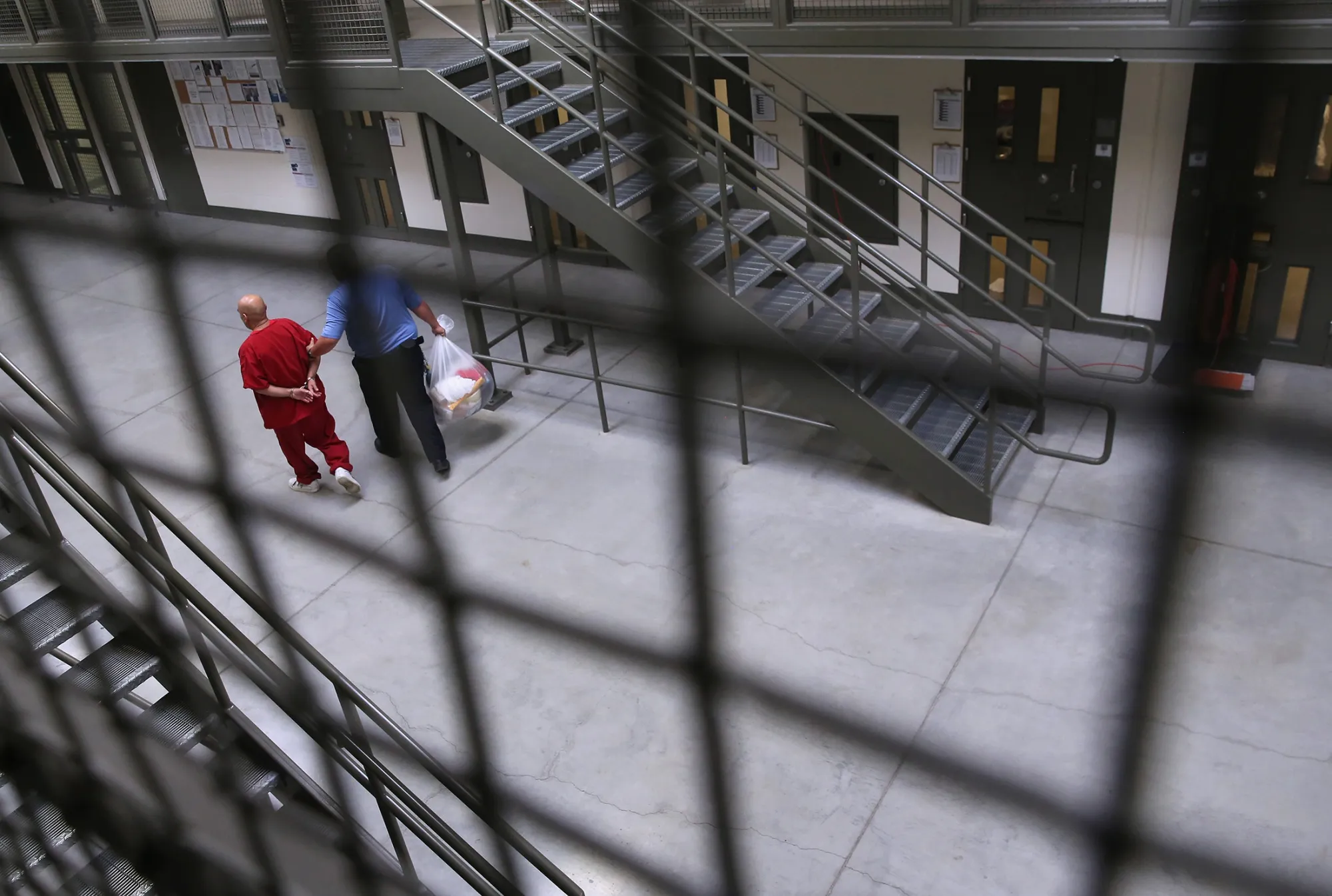 A guard escorts an immigrant detainee&nbsp;at a Geo Group detention facility.