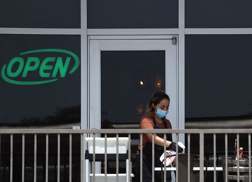 A restaurant employee cleans a outdoor patio table at Benny's Cafe prior to the Texas' scheduled reopening of businesses during the coronavirus (COVID-19) pandemic on April 27, 2020 in Colleyville, Texas. 