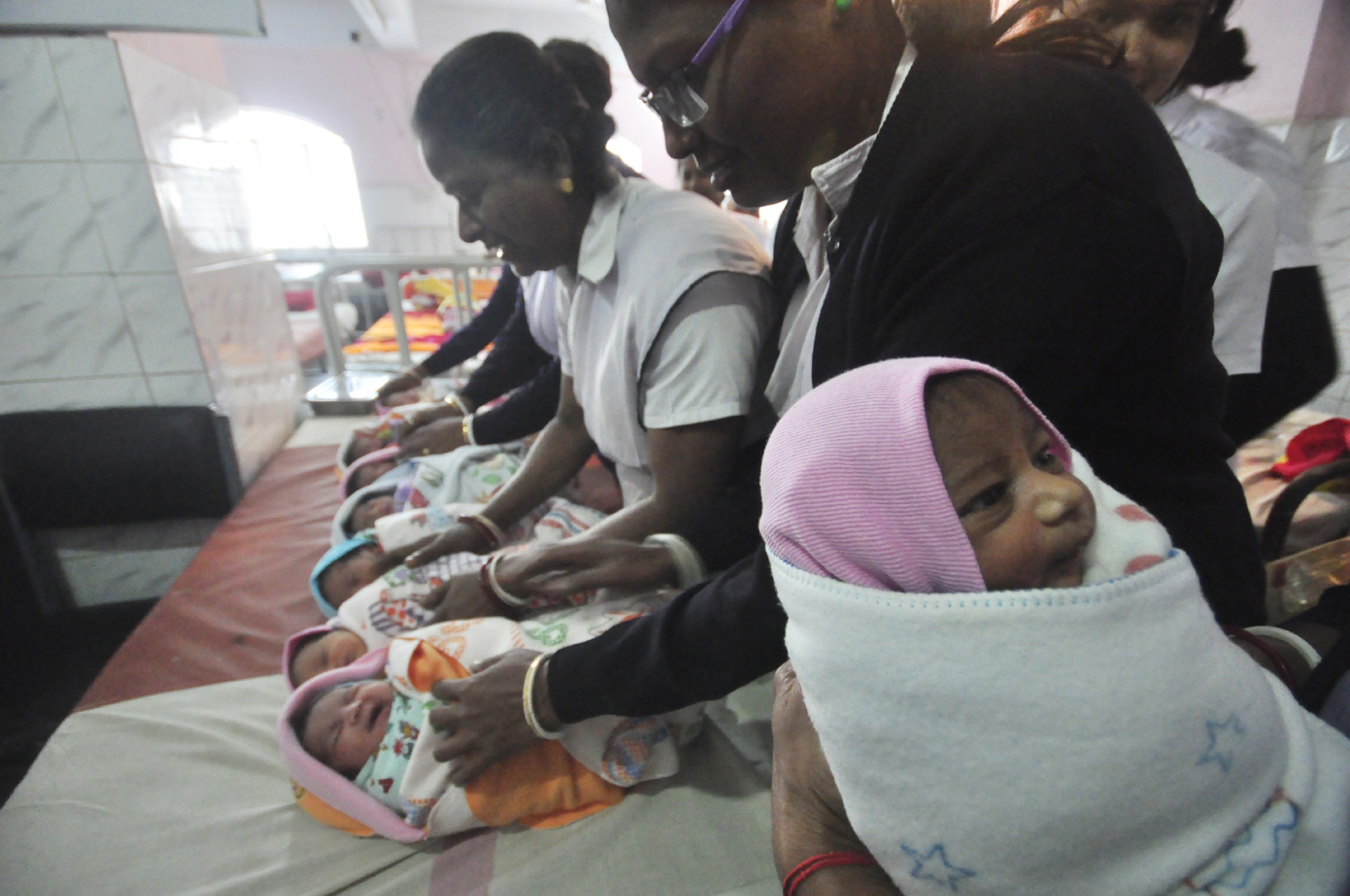 Nurses in India hold newborn babies inside a maternity ward on January 01, 2017.