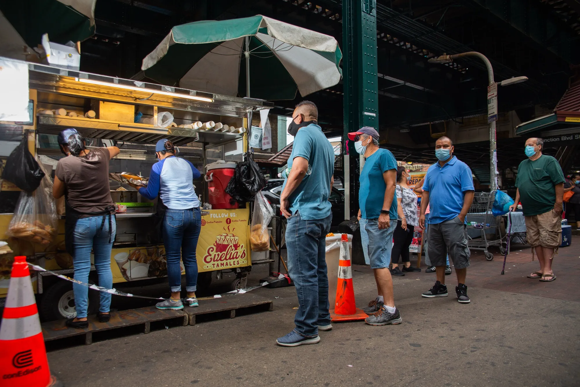 Customers stand in line outside a food cart in New York, on June 27.