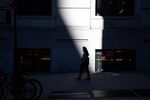 A pedestrian wearing a protective mask walks toward the New York Stock Exchange (NYSE) in New York, U.S., on Monday, Nov. 9, 2020.