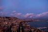 Aerial view of the hills of Naples. The sky is getting dark and the clouds have a pink colour.