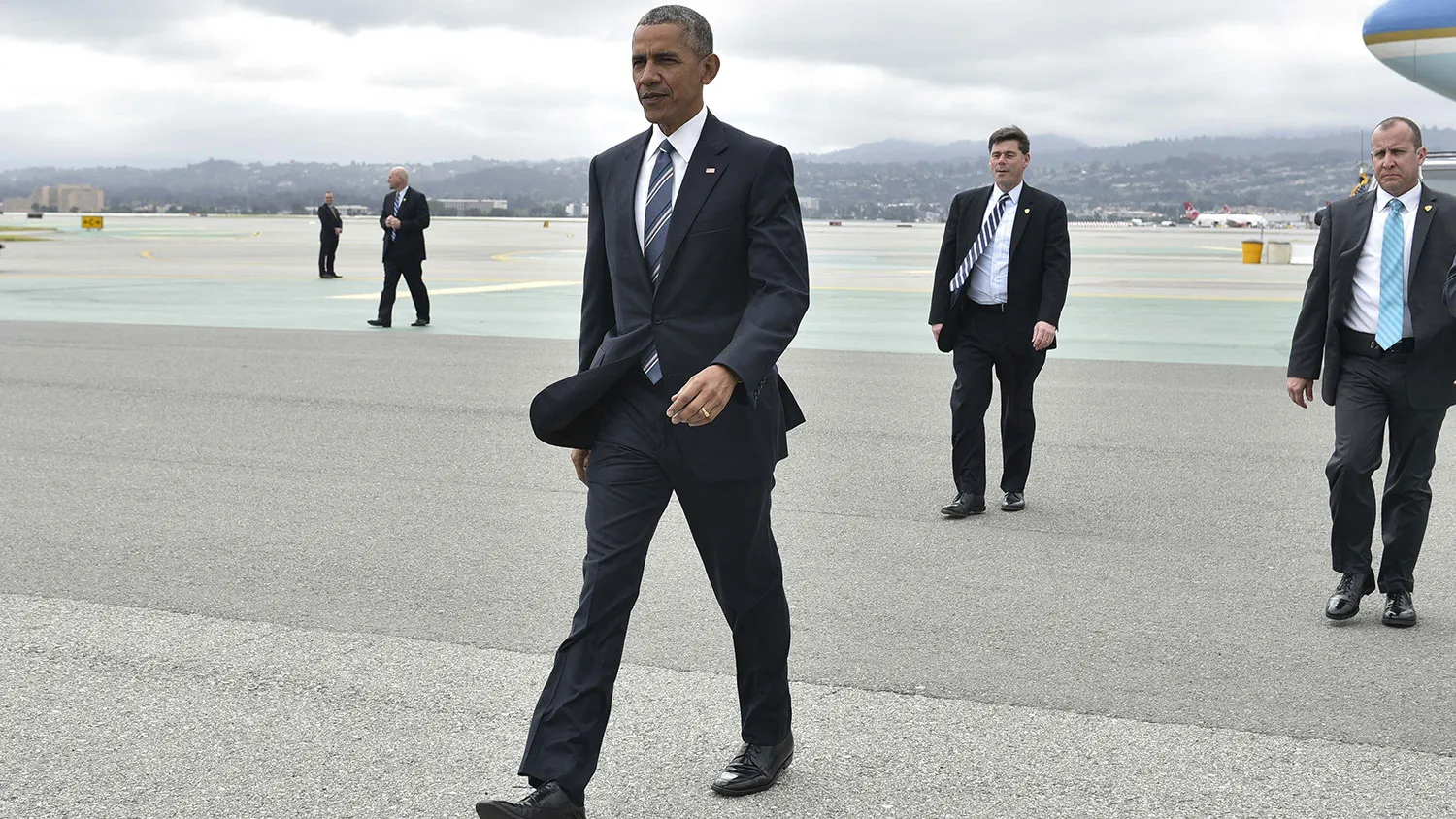 President Barack Obama walks across the tarmac to greet well-wishers upon arrival at San Francisco International Airport on April 8, 2016.
