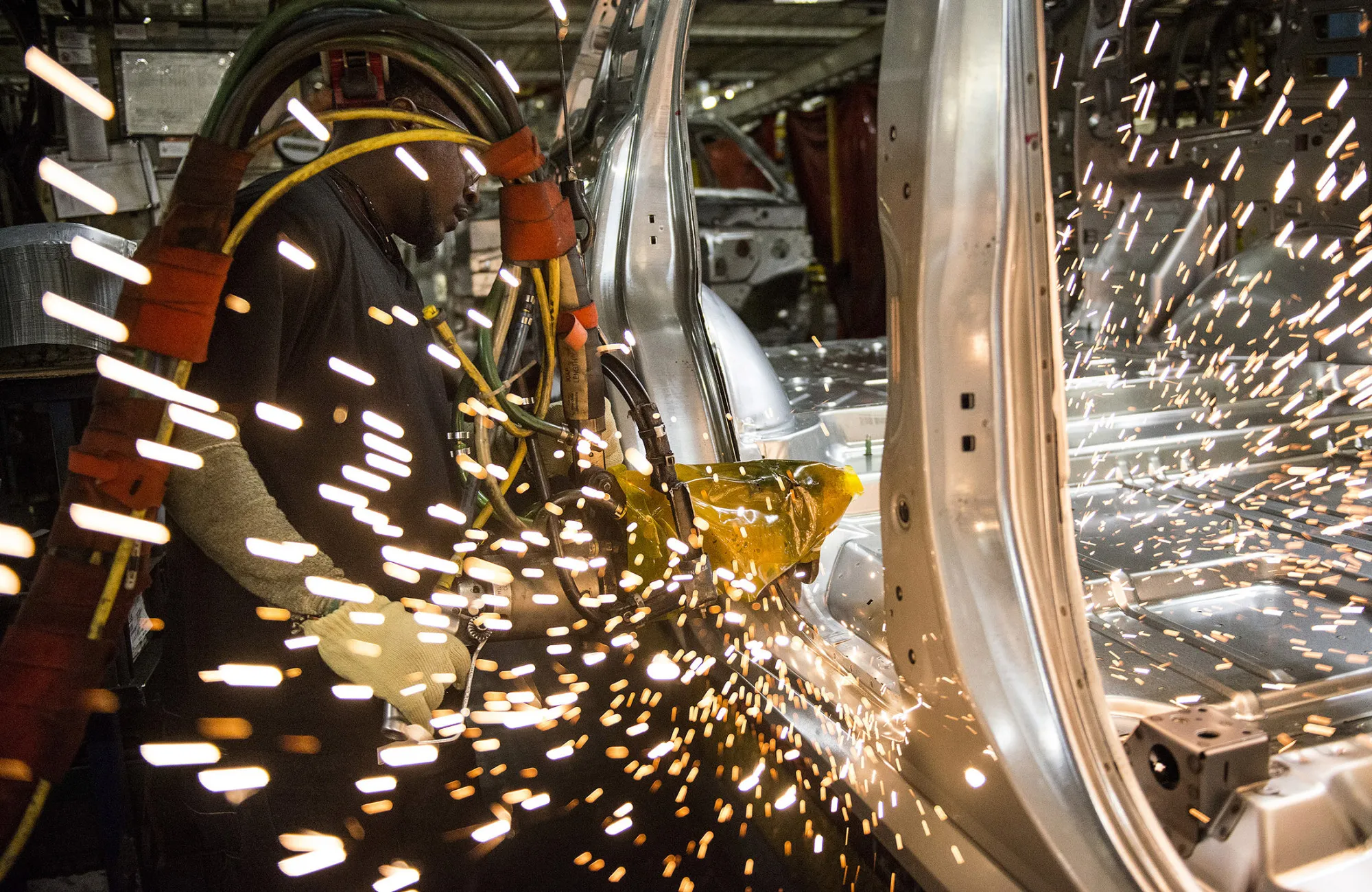An employee welds together a frame for a vehicle at an assembly plant in Arlington, Texas.
