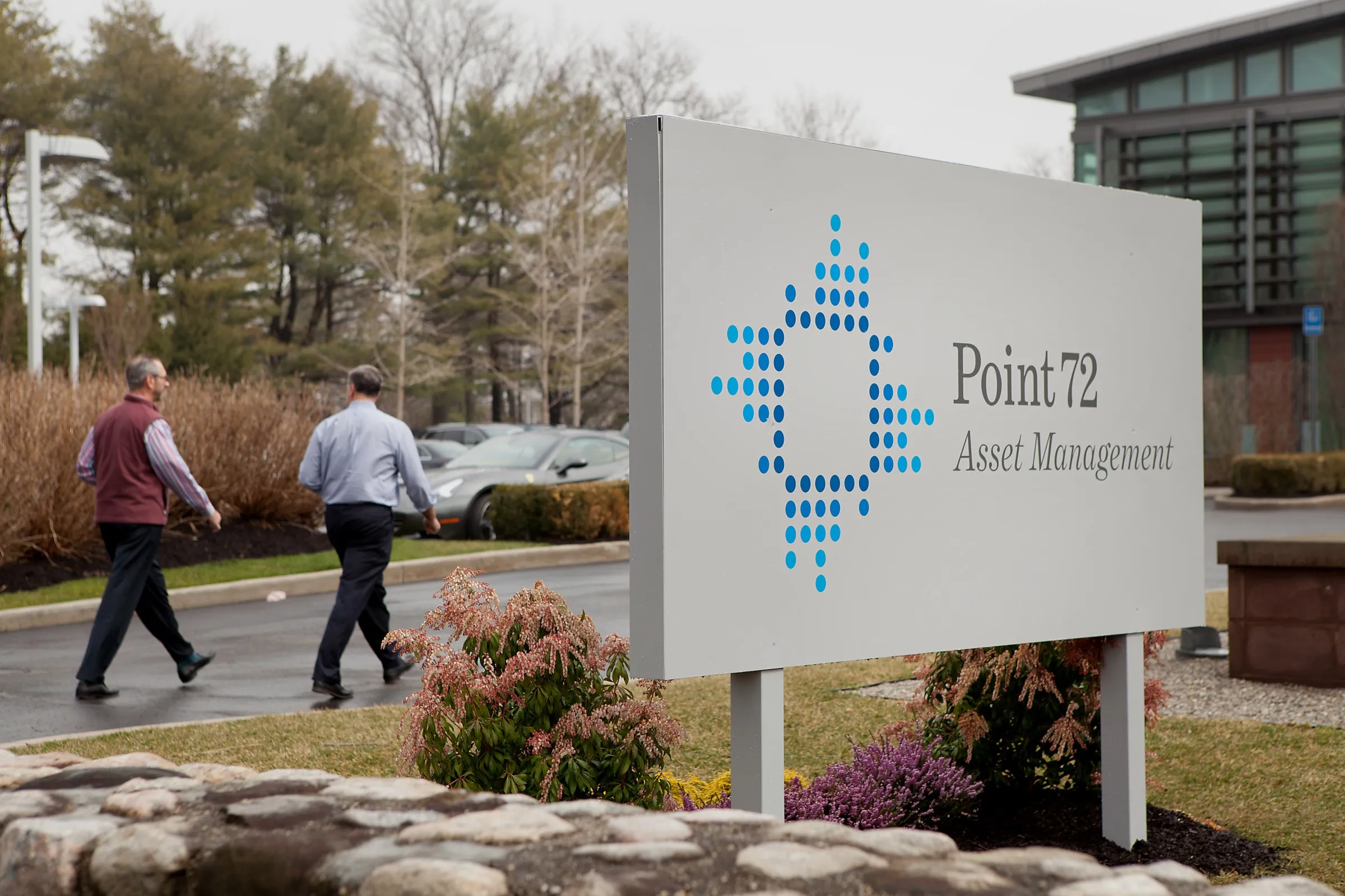 Employees walk outside of Point72 Asset Management LP in Stamford, Connecticut.