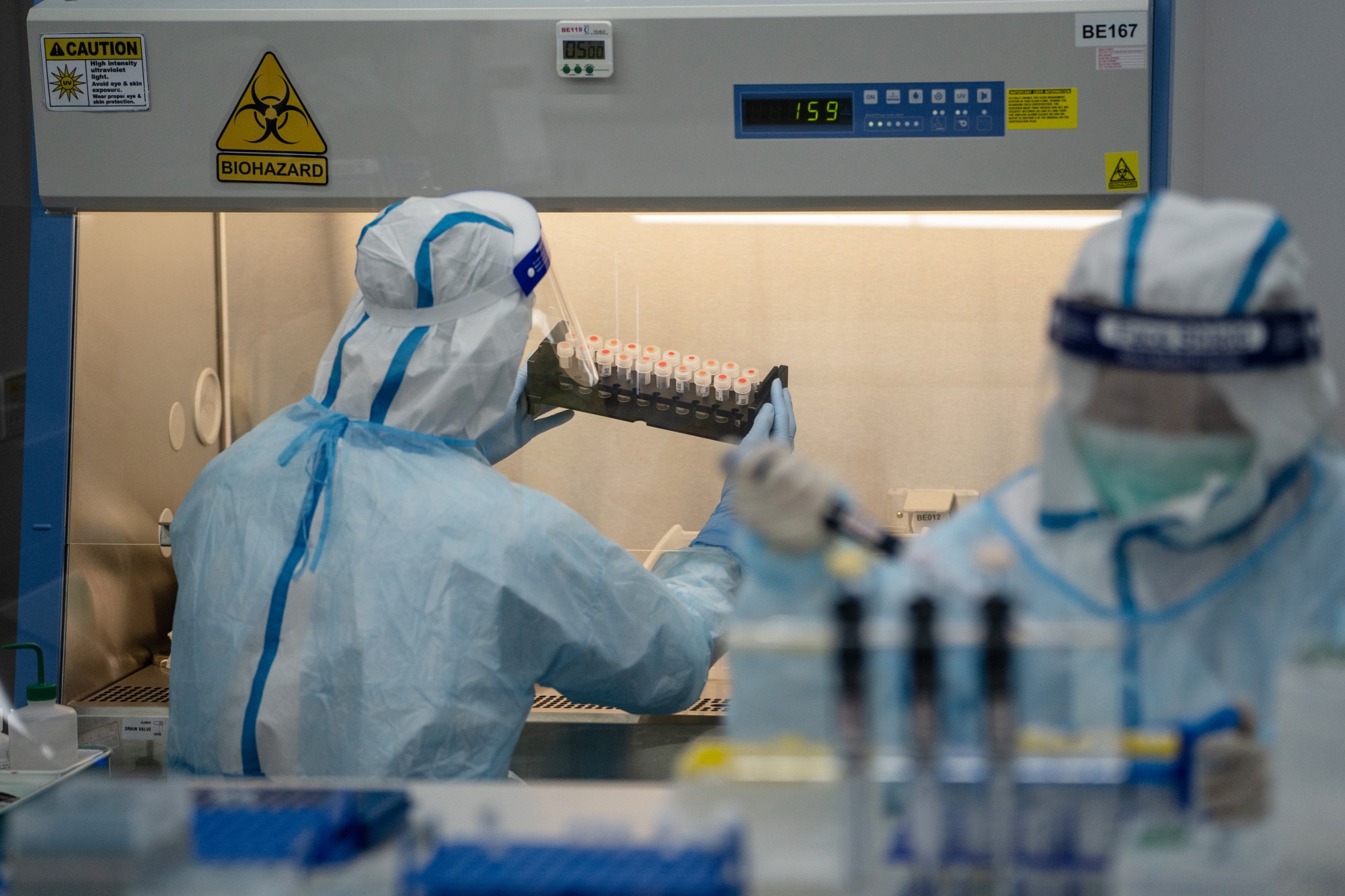 A lab technician wearing a protective suit handles saliva samples for Covid-19 testing at a laboratory in Hong Kong, on July 31.