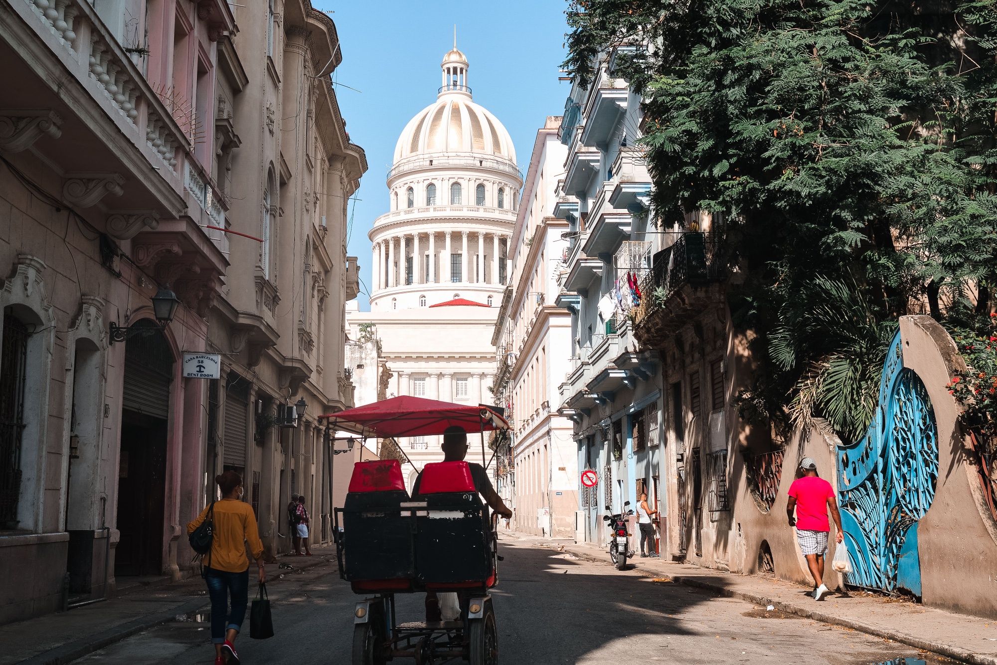 A pedicab travels towards the National Capitol building in Havana, Cuba.