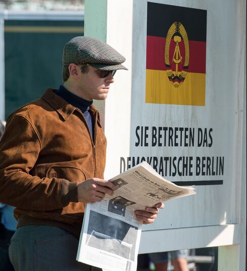 Hammer's Illya Kuryakin in his luxe,-yet-simple uniform: custom W. Bill wool cap, Persol shades, Ralph Lauren suede bomber jacket, and John Smedley merino wool turtleneck.