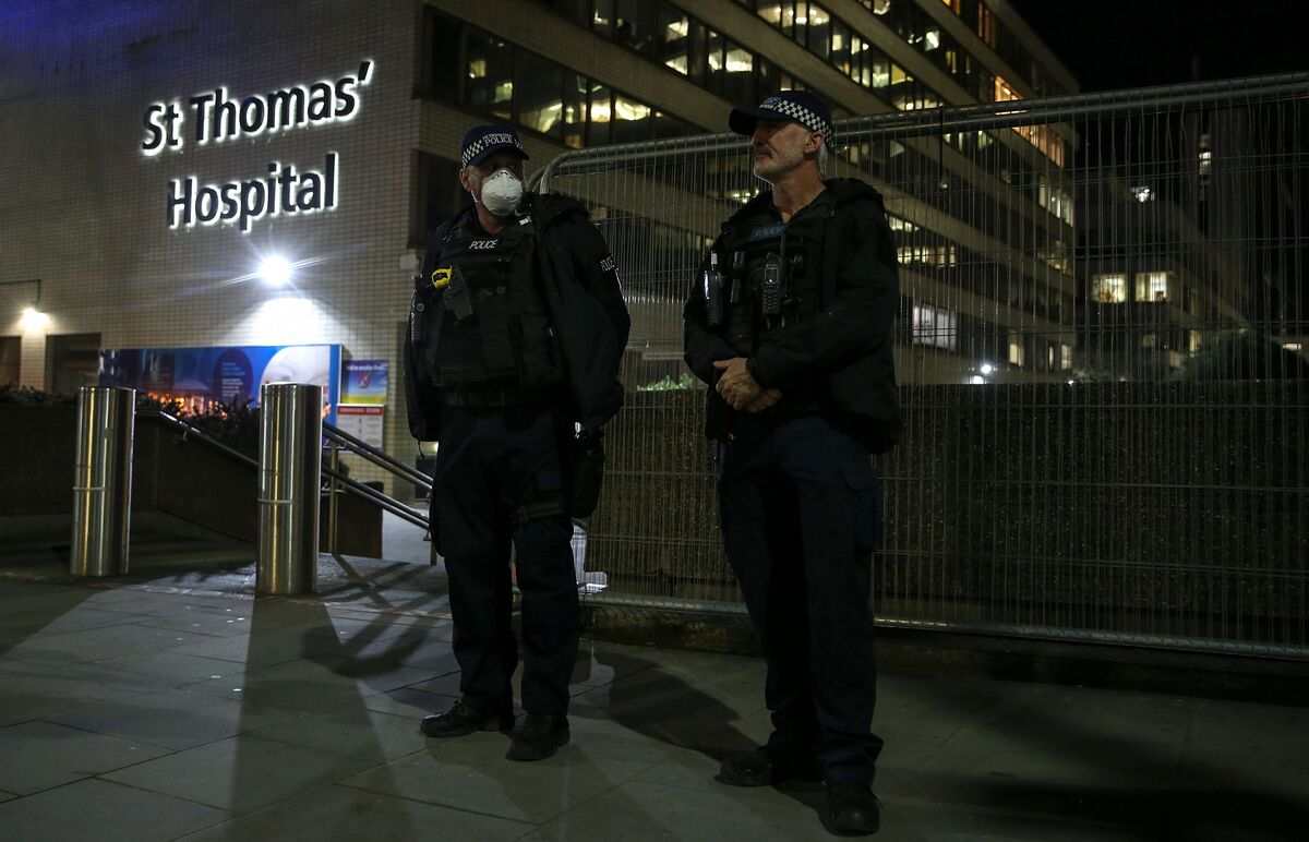 Police officers stand outside St Thomas’ Hospital in London, late on April 6.