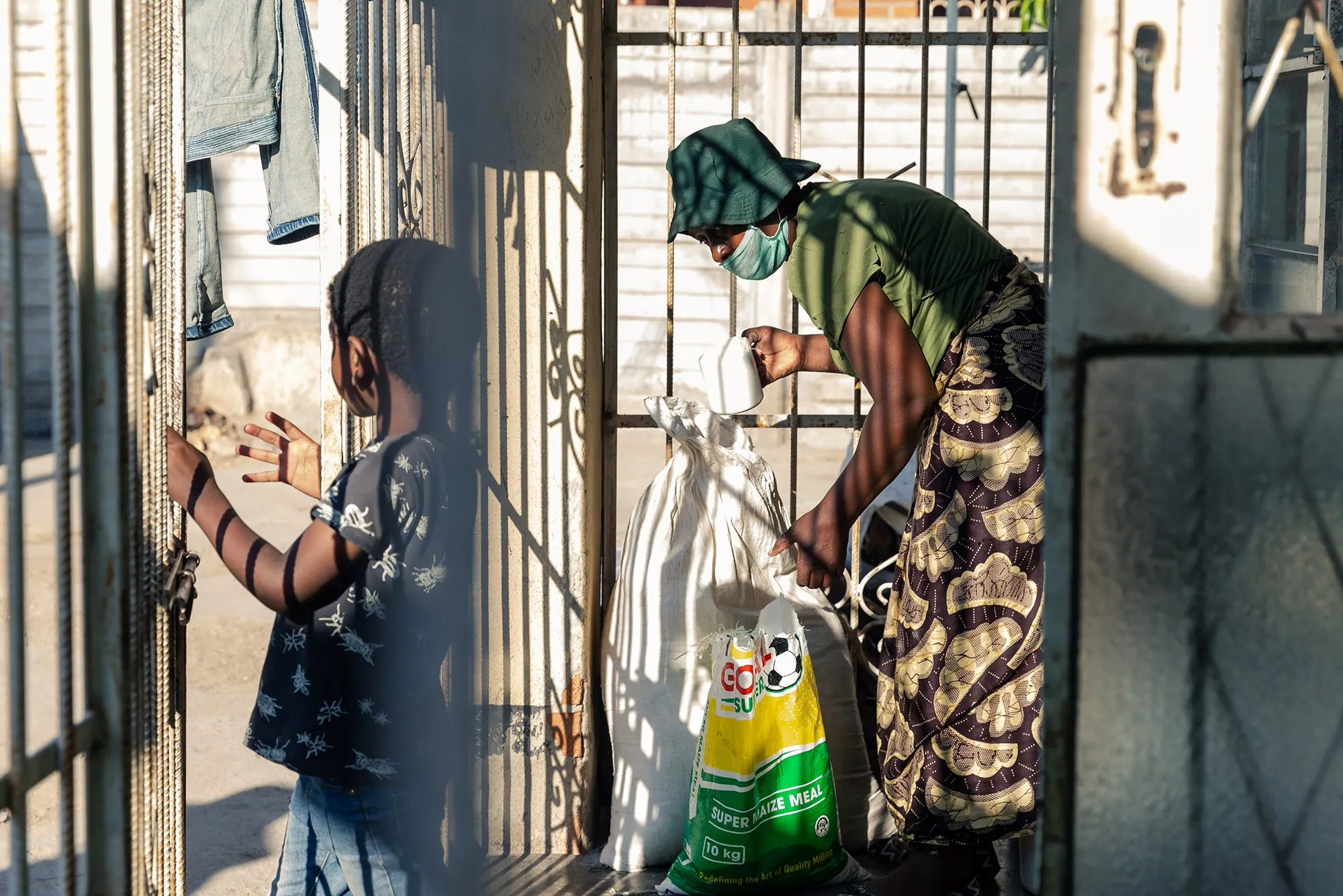 A volunteer takes a measure of mealie meal as she prepares to cook sadza for the underprivileged in Chitungwiza.