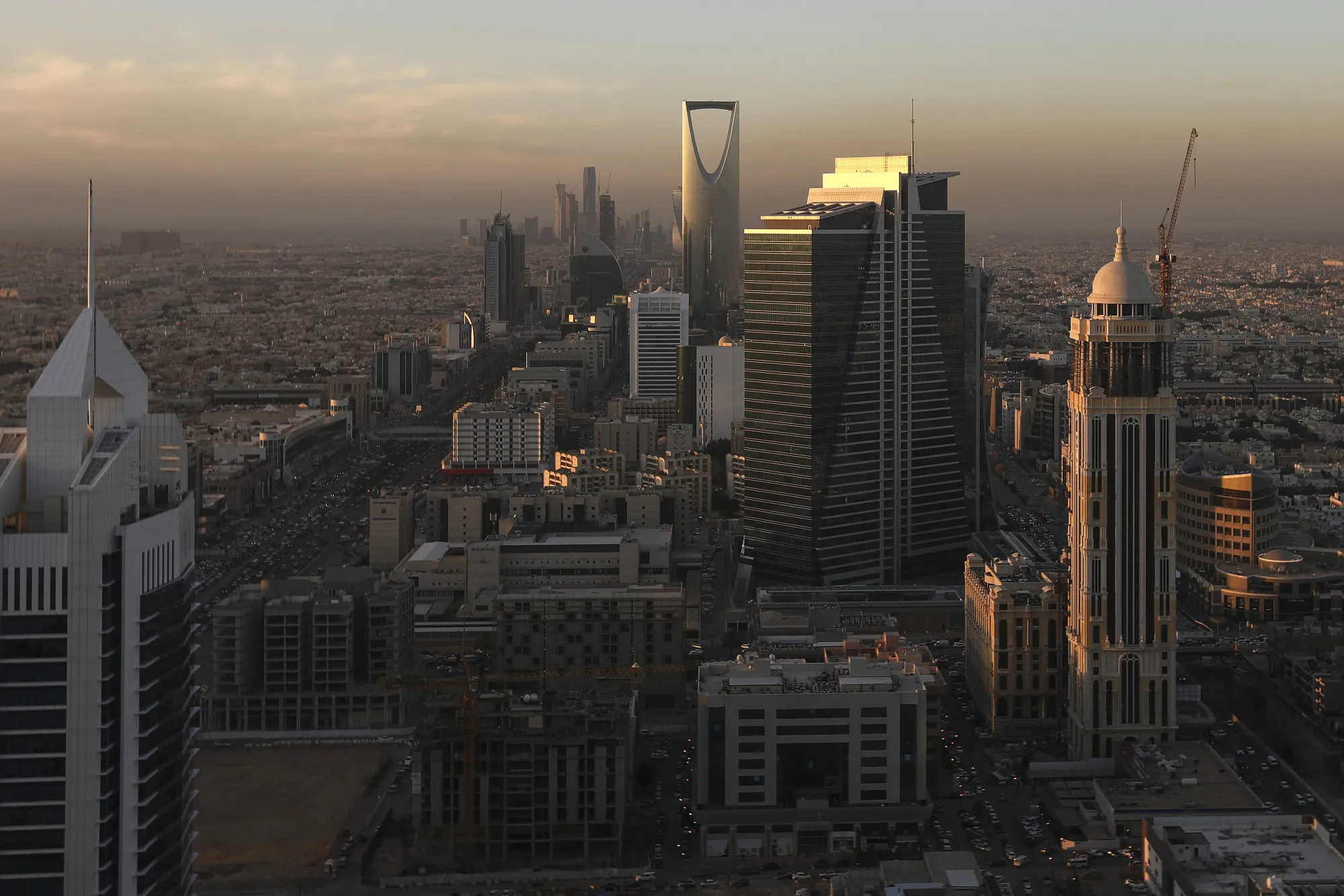 The Kingdom Tower, center rear, stands as automobile traffic moves along the King Fahd highway, left and Olaya Street, right, in Riyadh, Saudi Arabia.