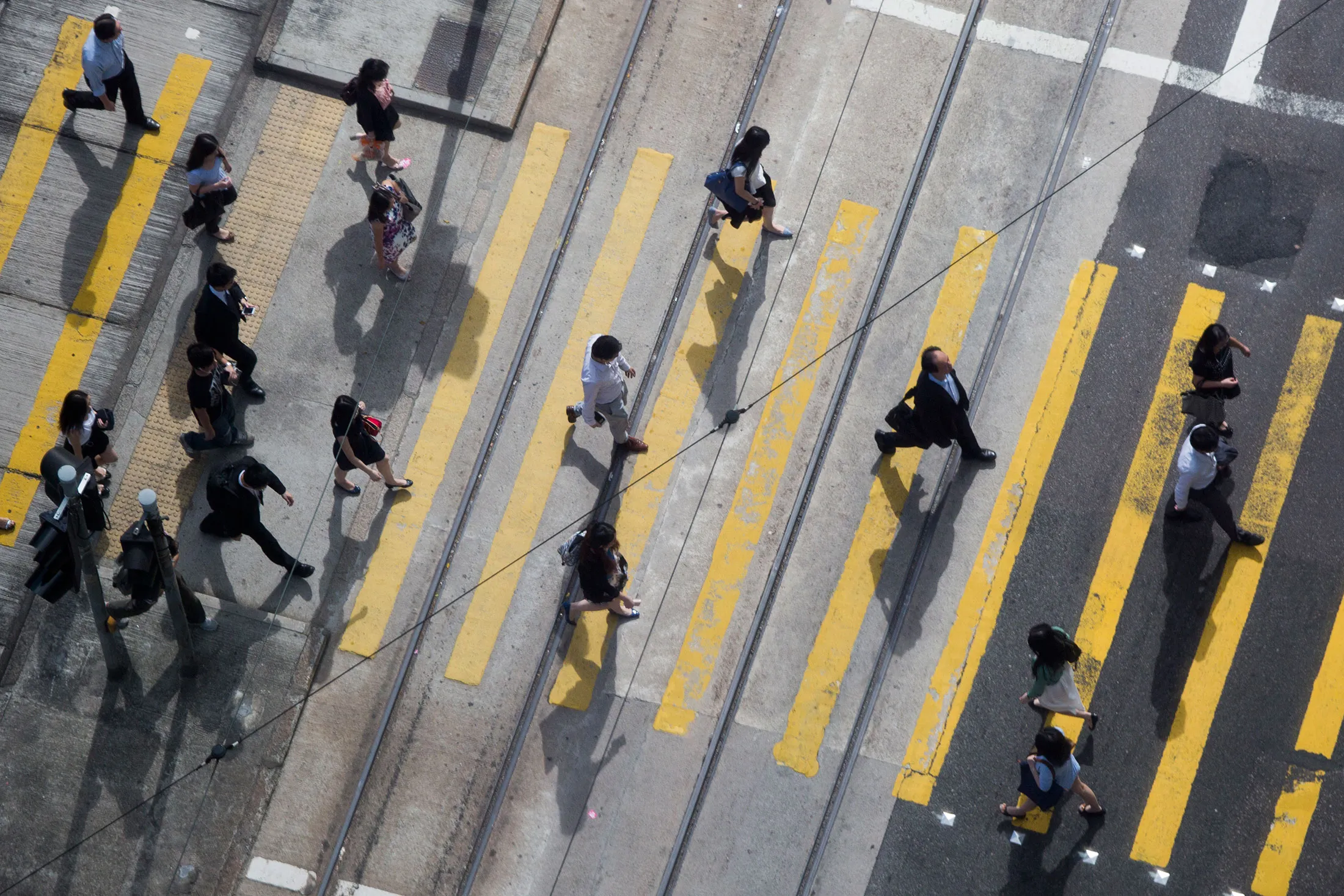 Commuters cross a street&nbsp;in Hong Kong, China.