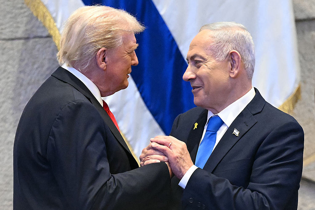 TOPSHOT - US President Donald Trump (L) holds hands and speaks with Israeli Prime Minister Benjamin Netanyahu at the Israeli parliament, the Knesset, in Jerusalem on October 13, 2025. Hamas handed over the 20 surviving Israeli hostages on October 13 under a ceasefire agreement, as the US President and other world leaders geared up for a summit on Gaza. The releases are part of a ceasefire agreement brokered by the US President, with Israel due in return to free nearly 2,000 detainees held in its jails in exchange. (Photo by SAUL LOEB / POOL / AFP) (Photo by SAUL LOEB/POOL/AFP via Getty Images) Photographer: SAUL LOEB/AFP