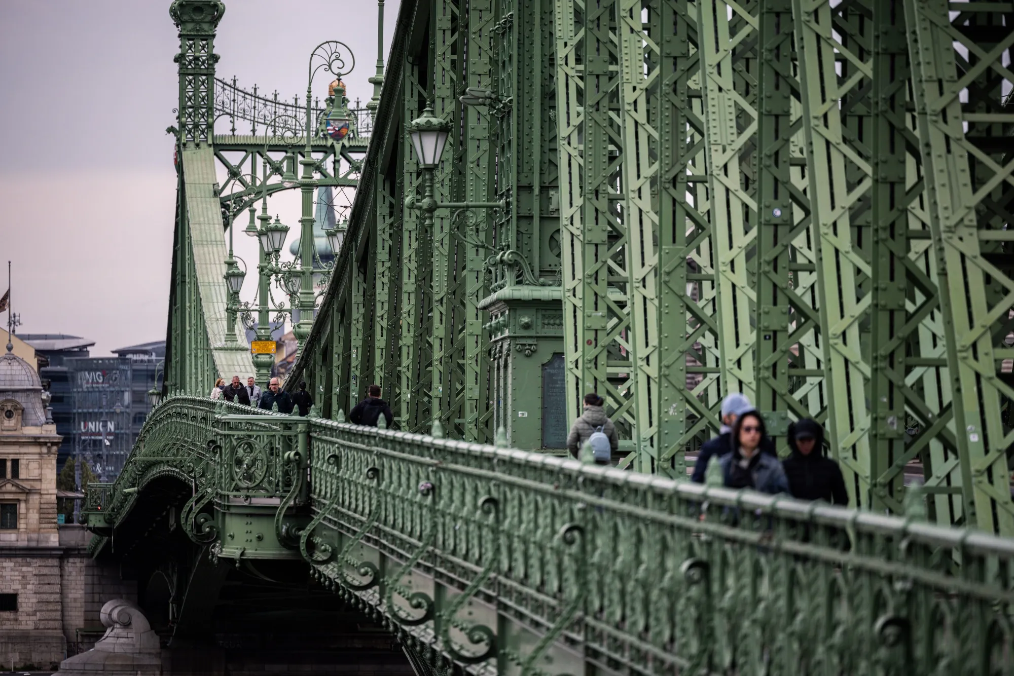 Pedestrians cross Liberty Bridge in Budapest, Hungary.