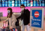 Passengers wear protective masks as they arrive at the Los Angeles International Airport, California, U.S.