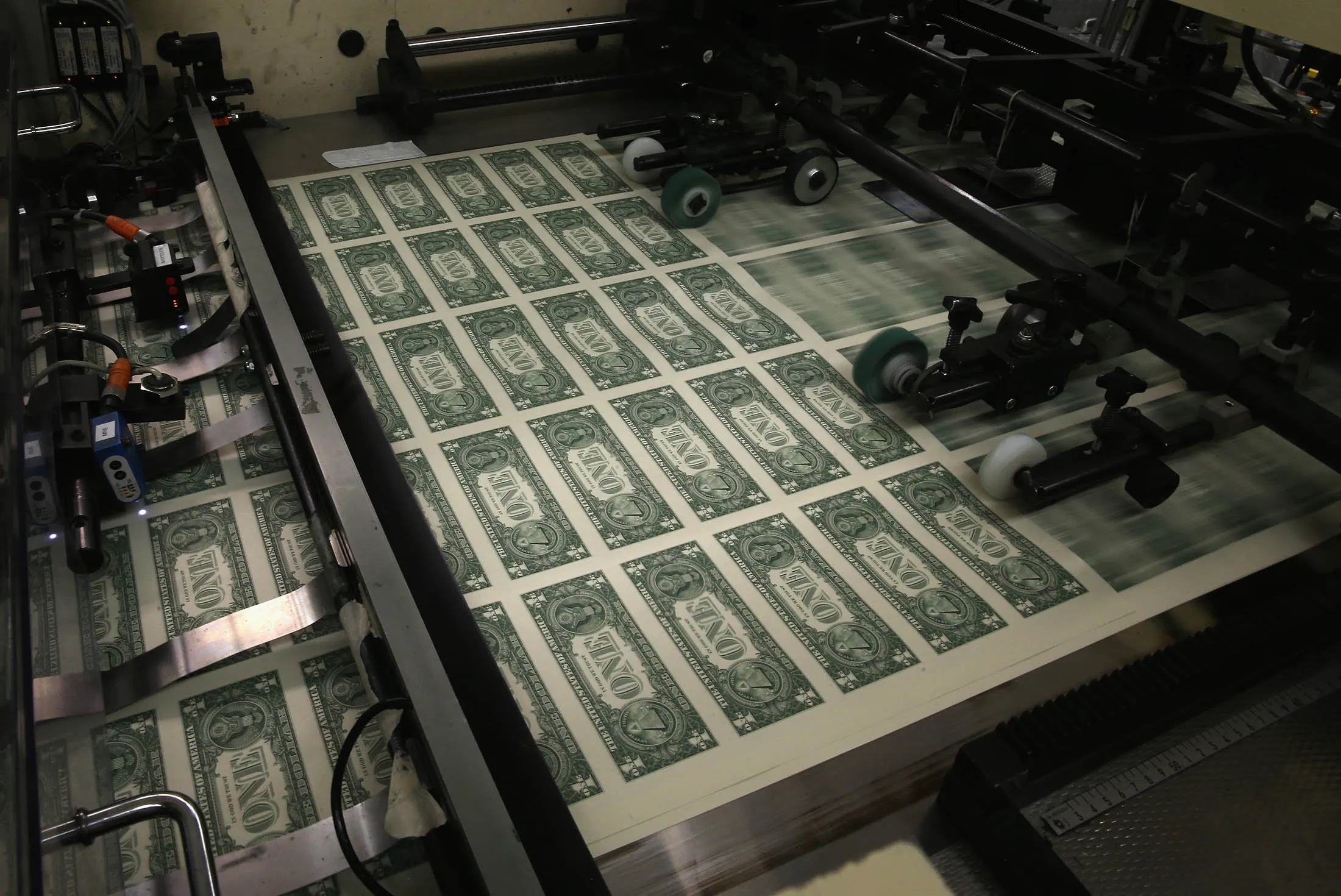 WASHINGTON, DC - MARCH 24: Sheets of one dollar bills run through the printing press at the Bureau of Engraving and Printing on March 24, 2015 in Washington, DC. The roots of The Bureau of Engraving and Printing can be traced back to 1862, when a single room was used in the basement of the main Treasury building before moving to its current location on 14th Street in 1864. The Washington printing facility has been responsible for printing all of the paper Federal Reserve notes up until 1991 when it shared the printing responsibilities with a new western facility that opened in Fort Worth, Texas.
