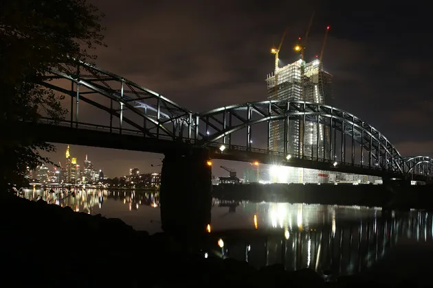 The European Central Bank's new headquarters, still under construction, right, stands beyond a rail bridge spanning the River Main in Frankfurt