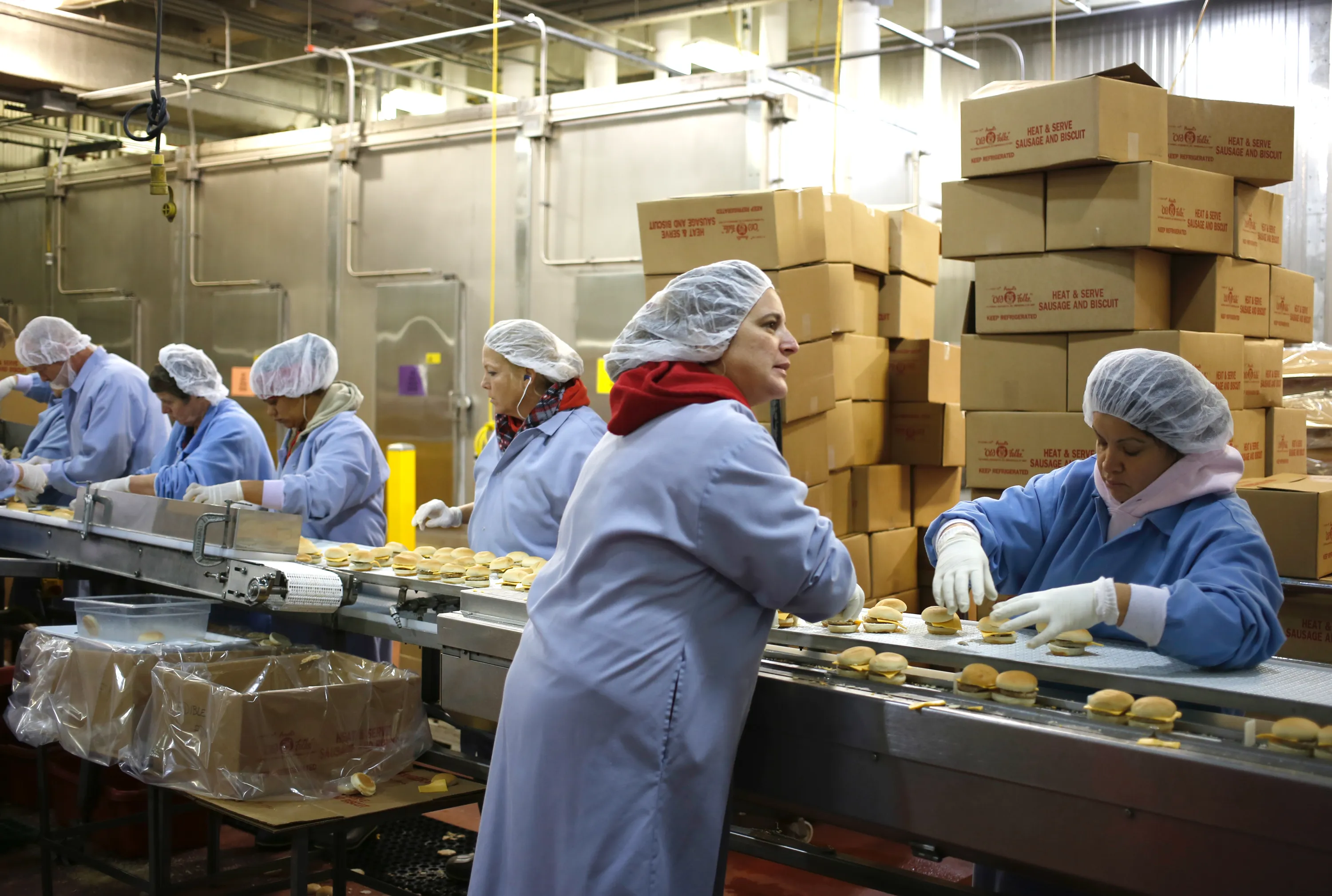 Workers assemble sandwiches on a conveyor belt at the Purnell Sausage Co. factory in Simpsonville, Kentucky, on Nov. 15, 2013. Photographer: Luke Sharrett/Bloomberg