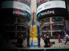Pedestrians pass in front of the Nasdaq MarketSite in the Times Square neighborhood of New York.