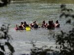 Beating the heat, a group sits in the Guadalupe River in New Braunfels, Texas.