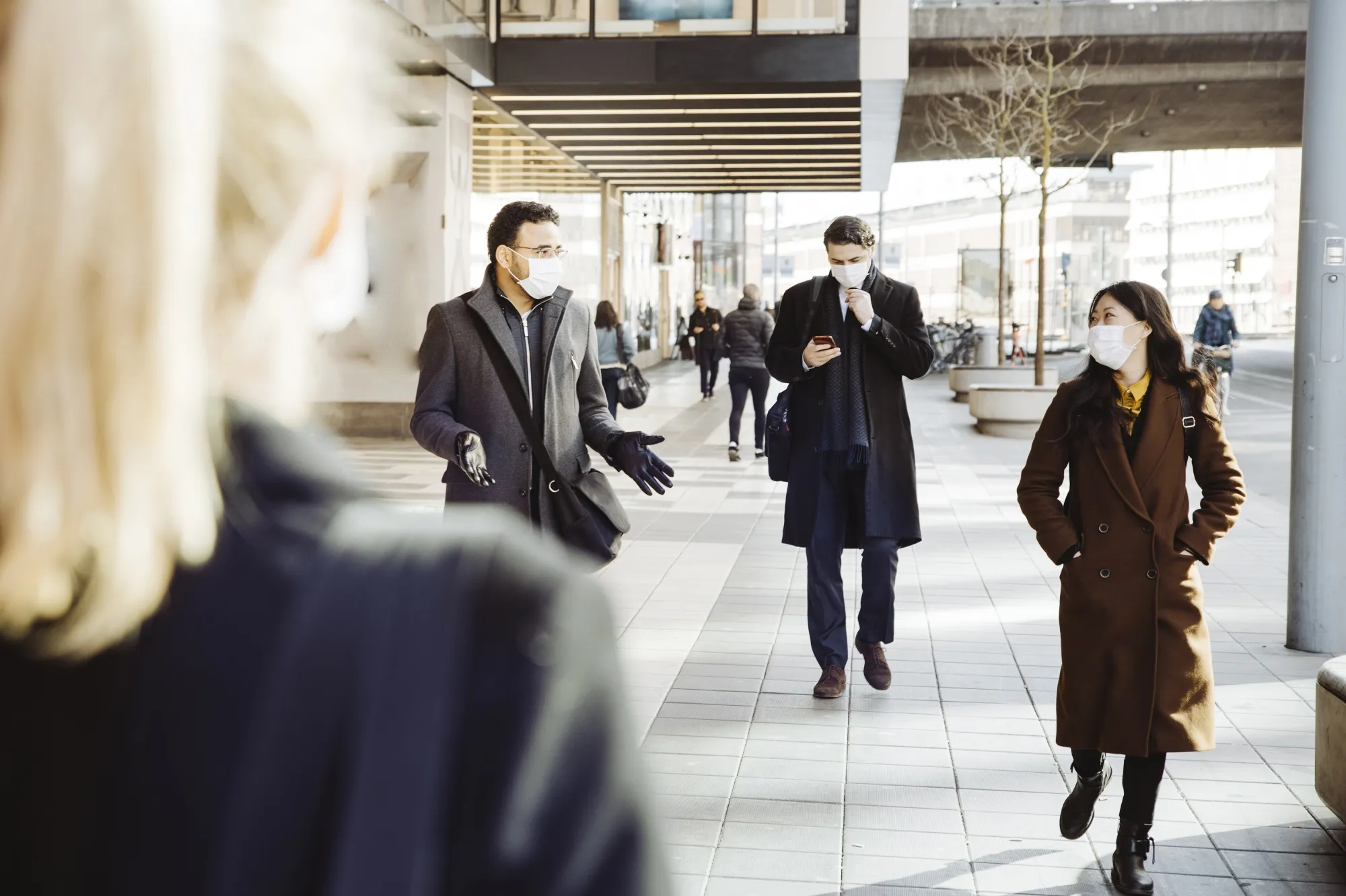 RF - Business people wearing face mask walking in street