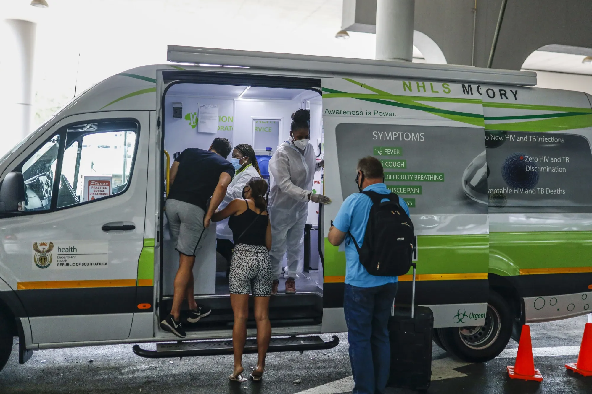 Passengers wait to be tested at a mobile Covid-19 testing unit at O.R Tambo International Airport in Johannesburg.