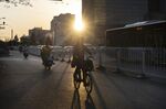 Cyclists ride along a road in Beijing.