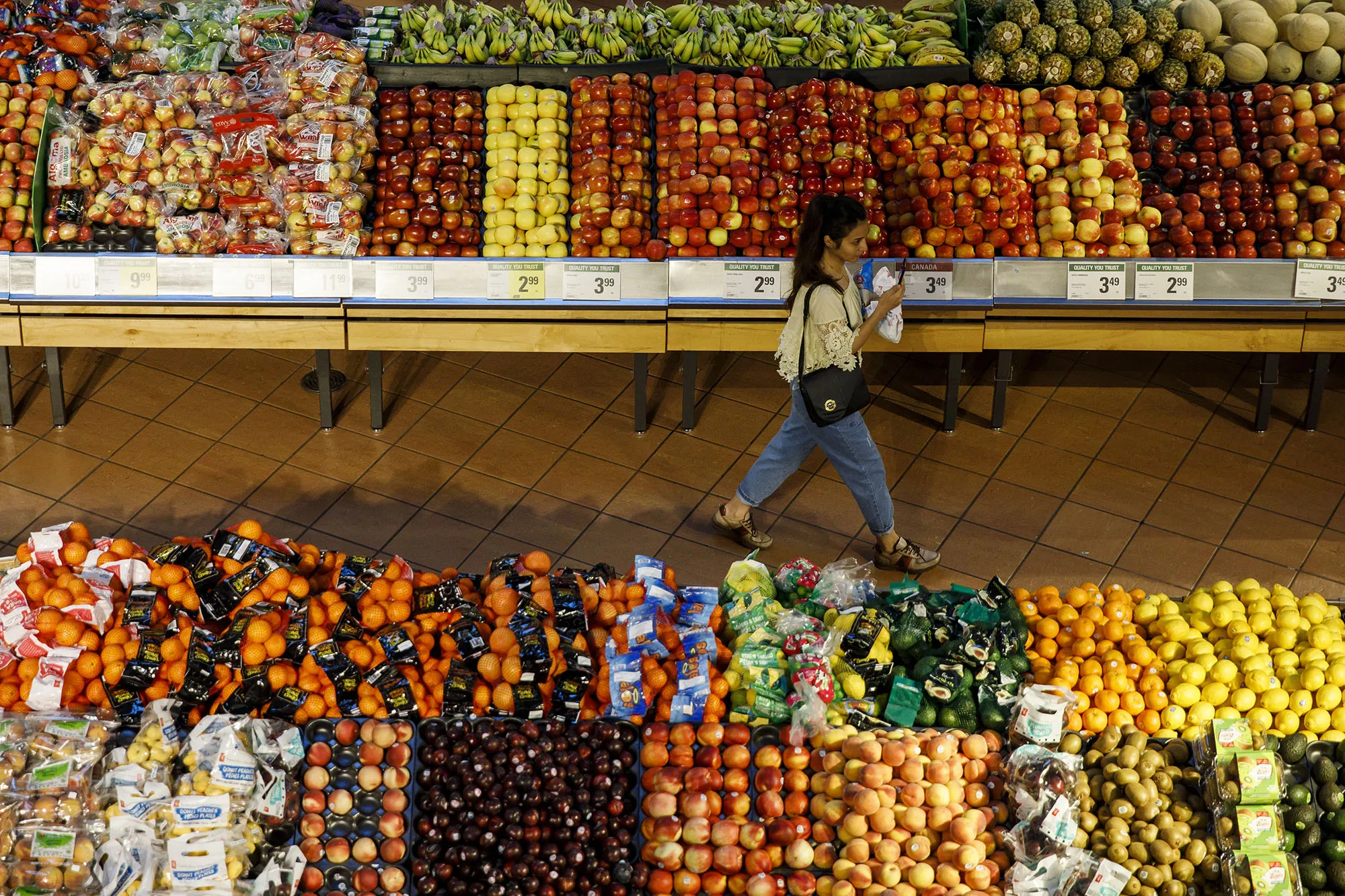 A shopper walks through a produce aisle at a grocery store in Toronto, Ontario.