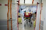 Medical personnel wheel coronavirus patients from an intensive care ward in Paris, France.