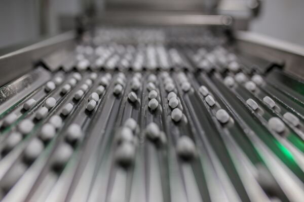 Tablets move along a conveyor. 