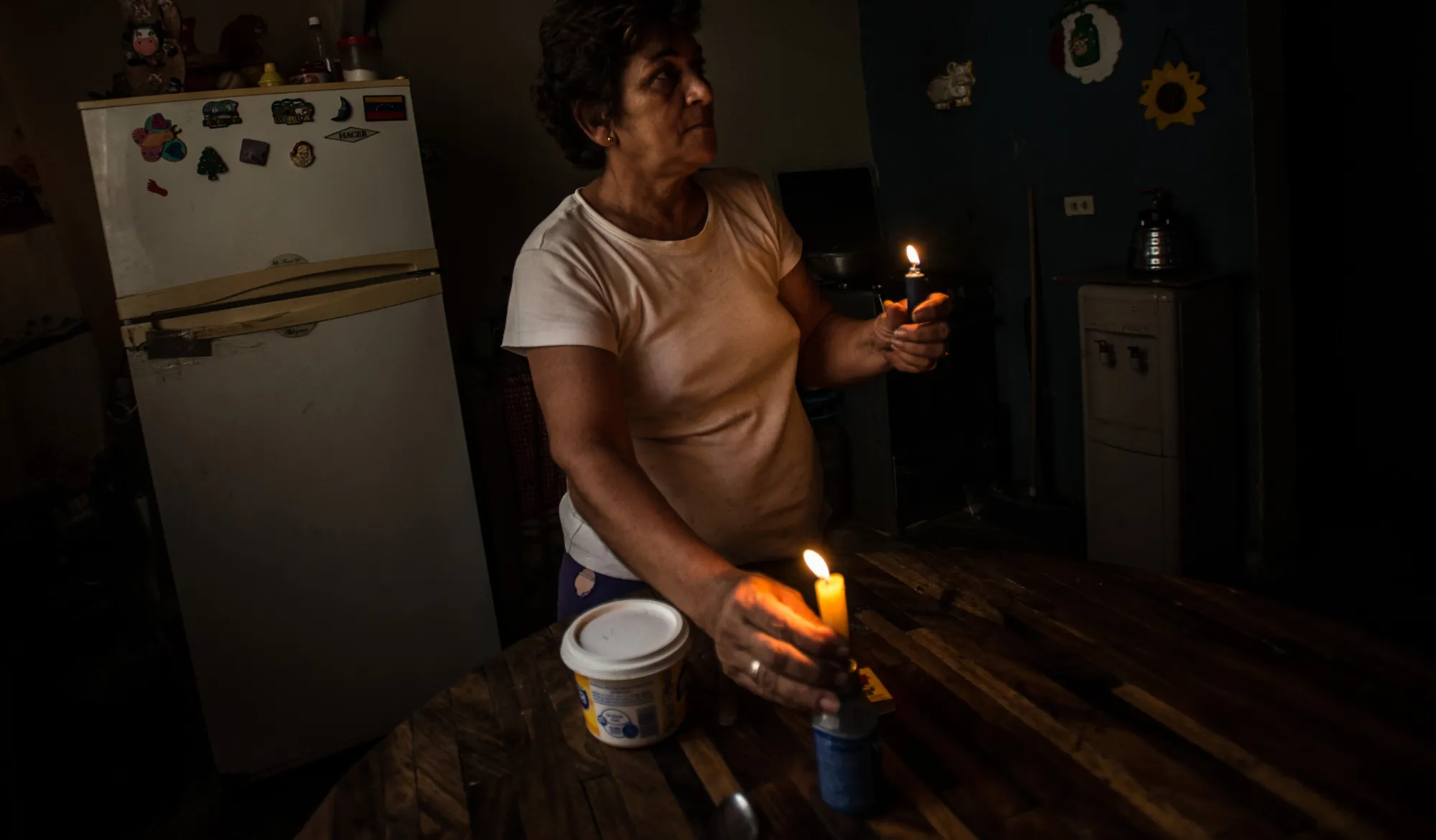 Nadia Rodriguez lights candles inside her home while electricity was shut off during state-mandated rationing in the Cana de Azucar neighborhood of Maracay, Venezuela, on March 21, 2016.
