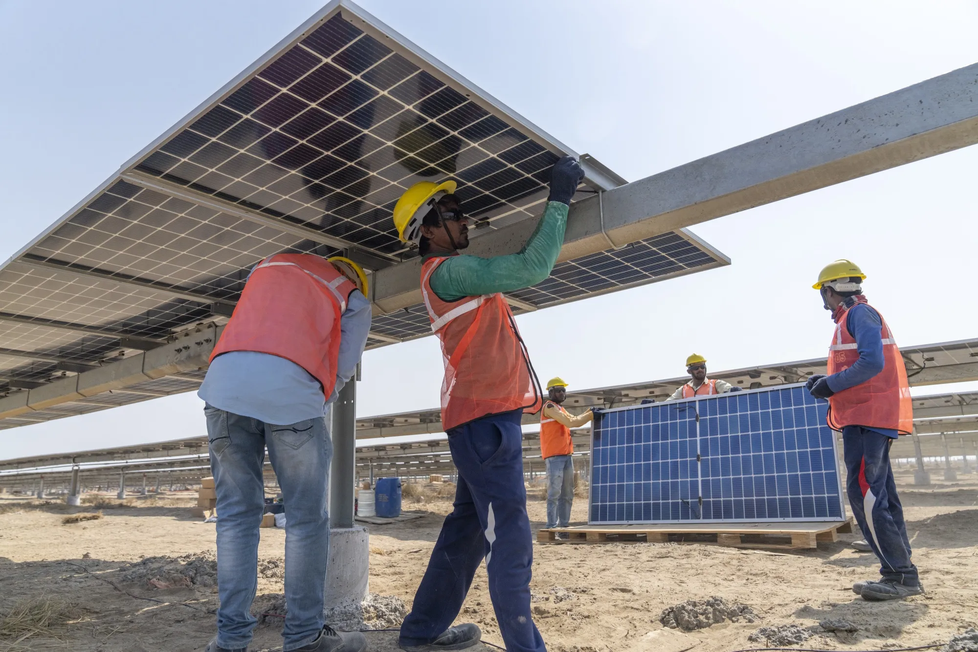 Workers install solar panels in Khavda, India.