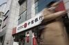 A pedestrian walks past a China Citic Bank Corp. branch in Shanghai, China, on Tuesday, March 21, 2017. China Citic is scheduled to release full-year earnings results on March 22.