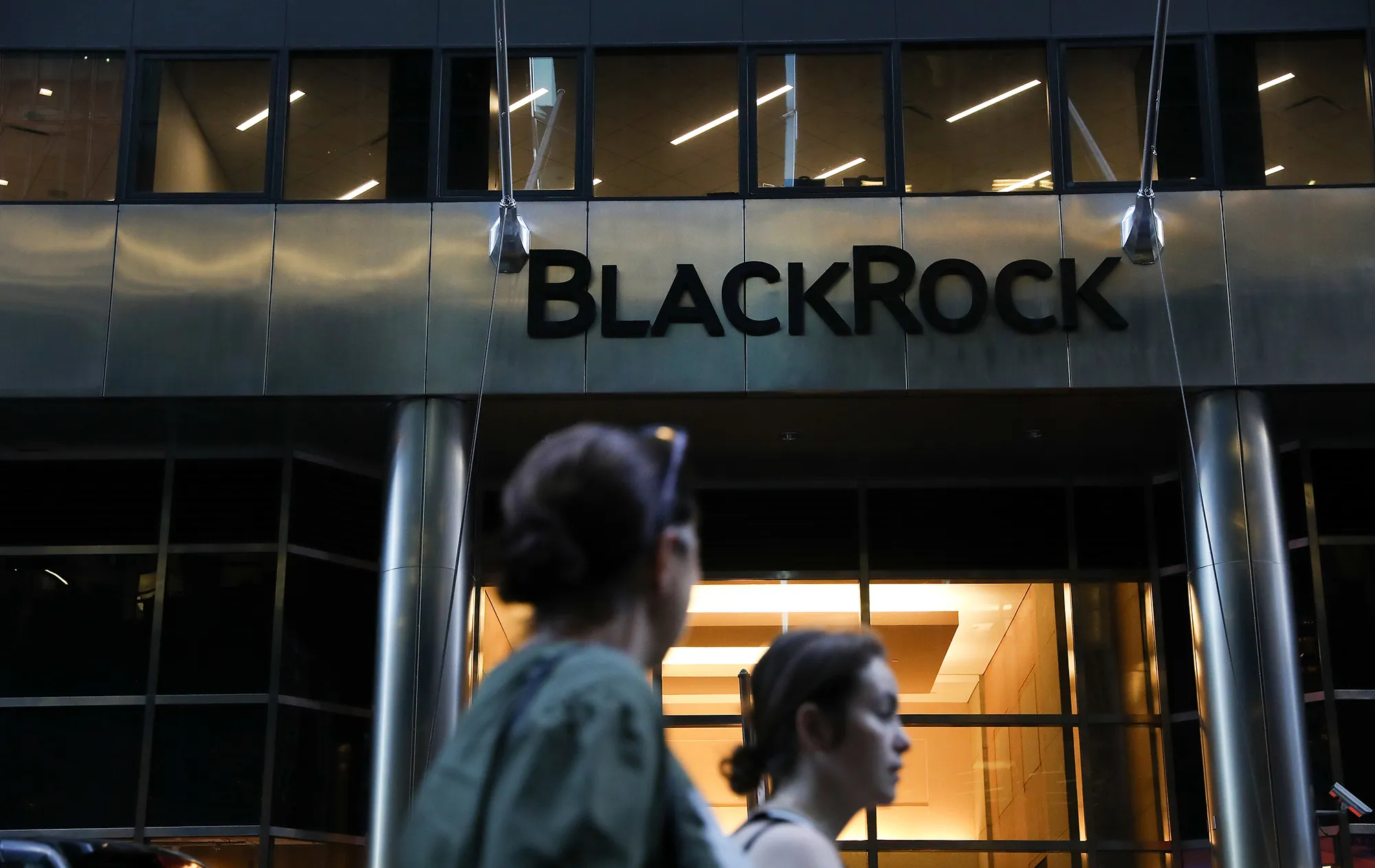 Pedestrians walk past BlackRock Inc. headquarters in New York.