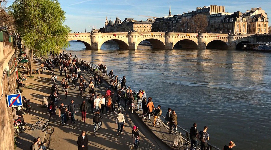 Parisians walk along the Seine on Sunday, one day after Paris closed cafes and restaurants.