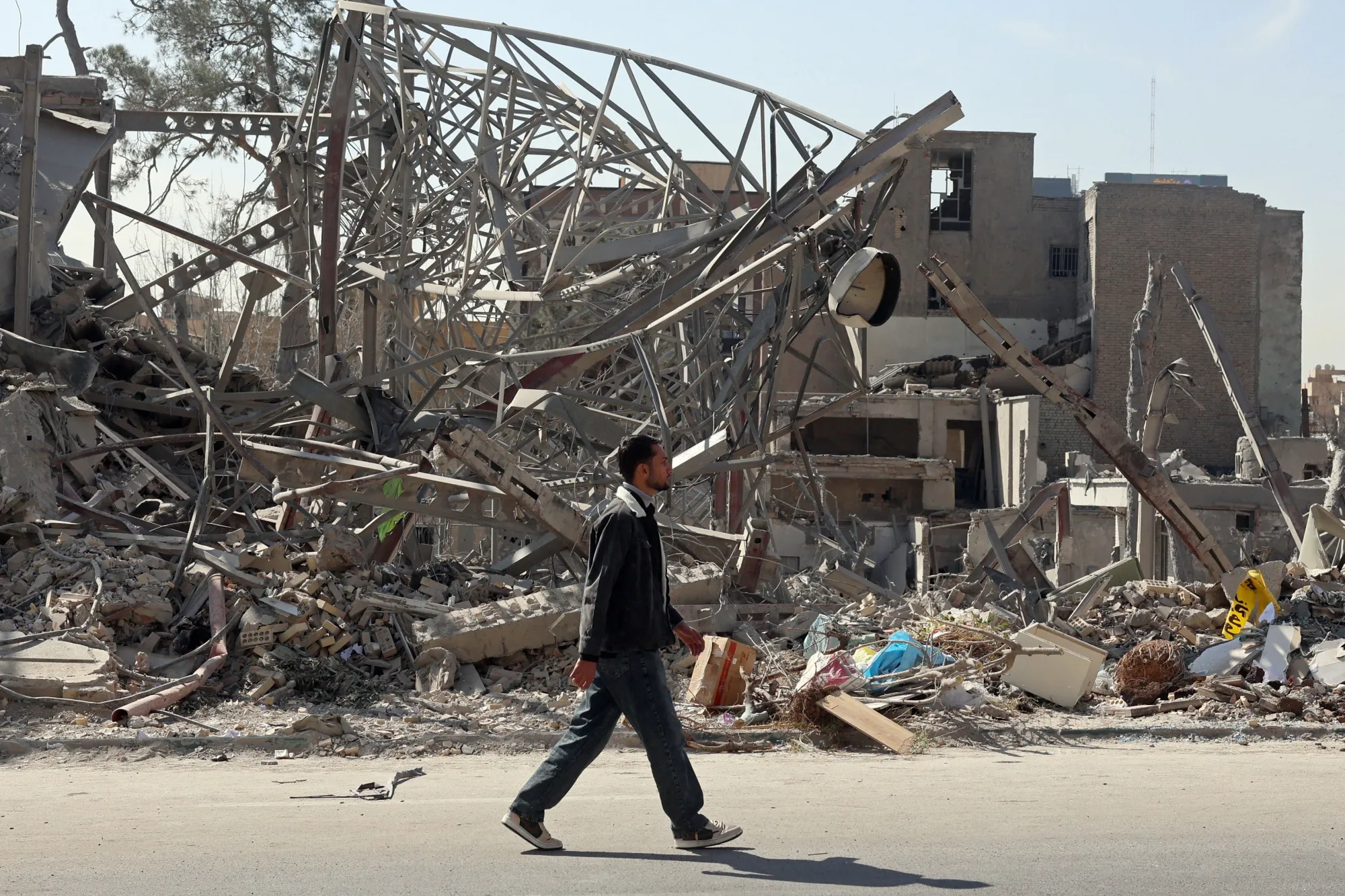 A man walks past destroyed buildings following airstrikes in central Tehran on March 4, 2026.&nbsp;