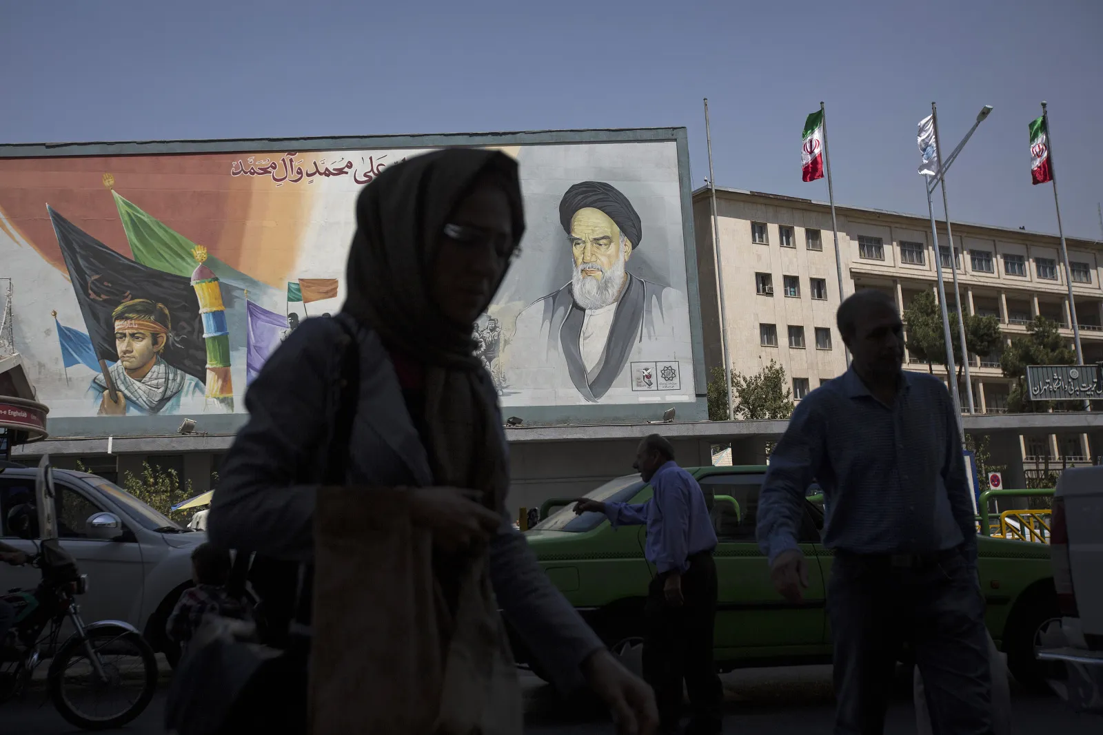 Pedestrians pass a&nbsp;mural depicting Ruhollah Khomeini, founder of the Islamic republic of Iran, in Tehran.
