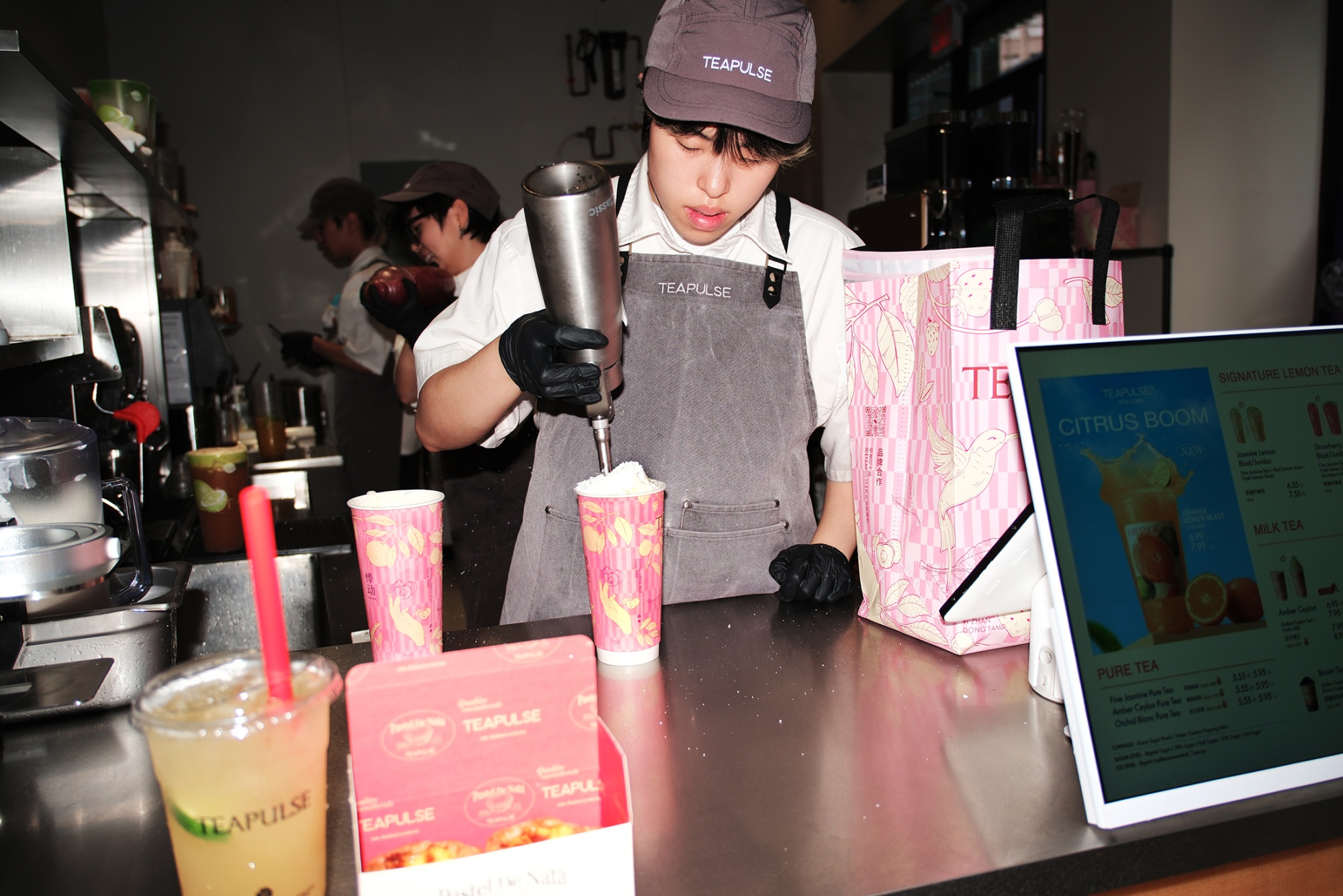 A Teapulse employee tops drinks with a cheese foam. Photographer: Kenneth Bachor/Bloomberg