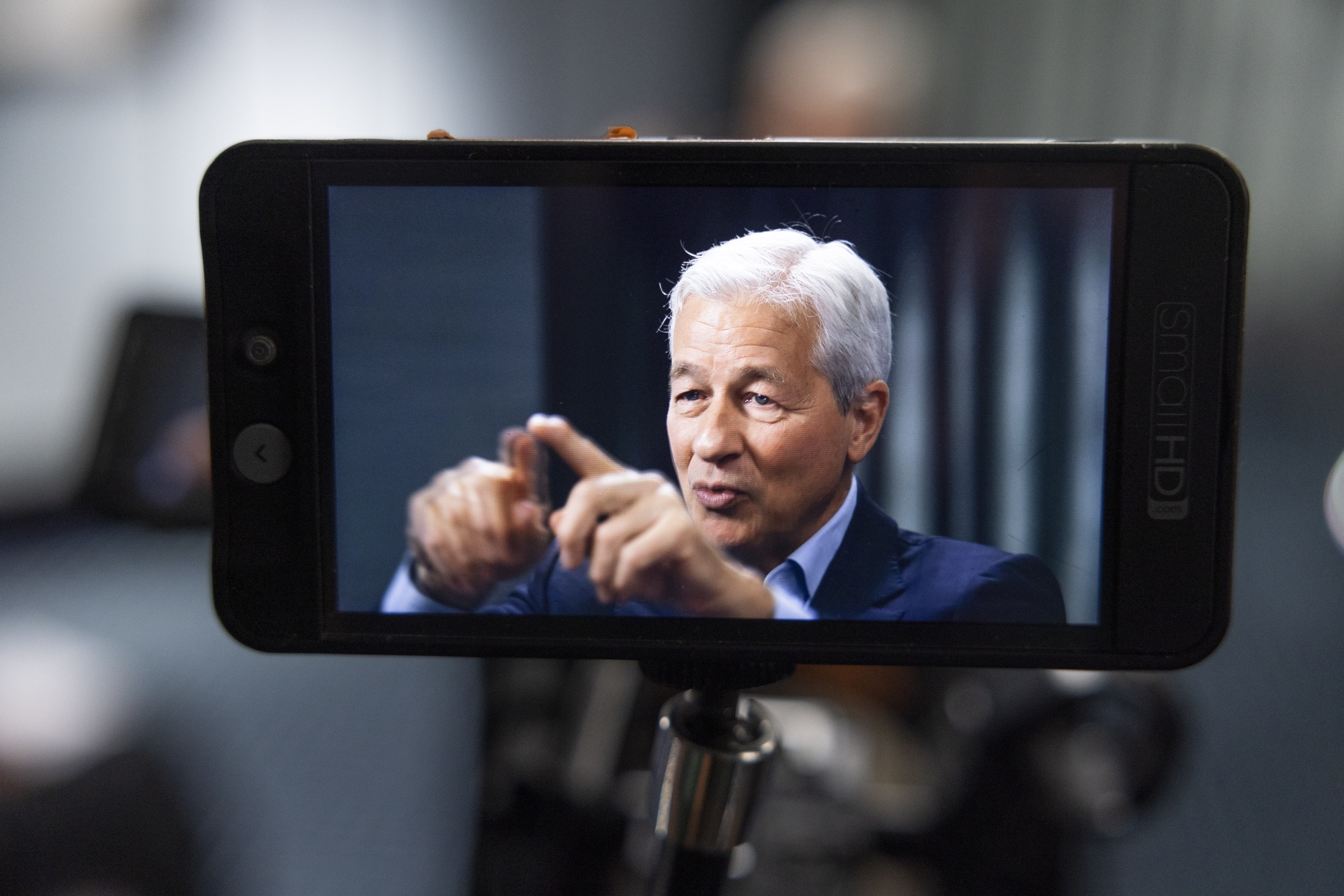 A monitor displaying an image of Jamie Dimon during an interview in London.